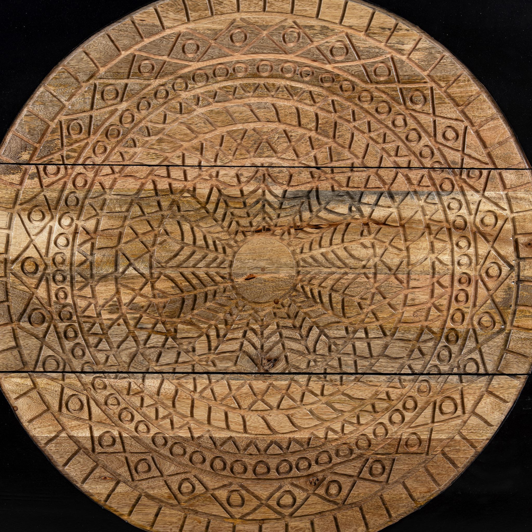 Close up image of a mandala carved wood chest with black frame and natural carved mango wood drawers, mango wood drawer chest for modern bohemian interiors, 120 × 47 × 110 cm.