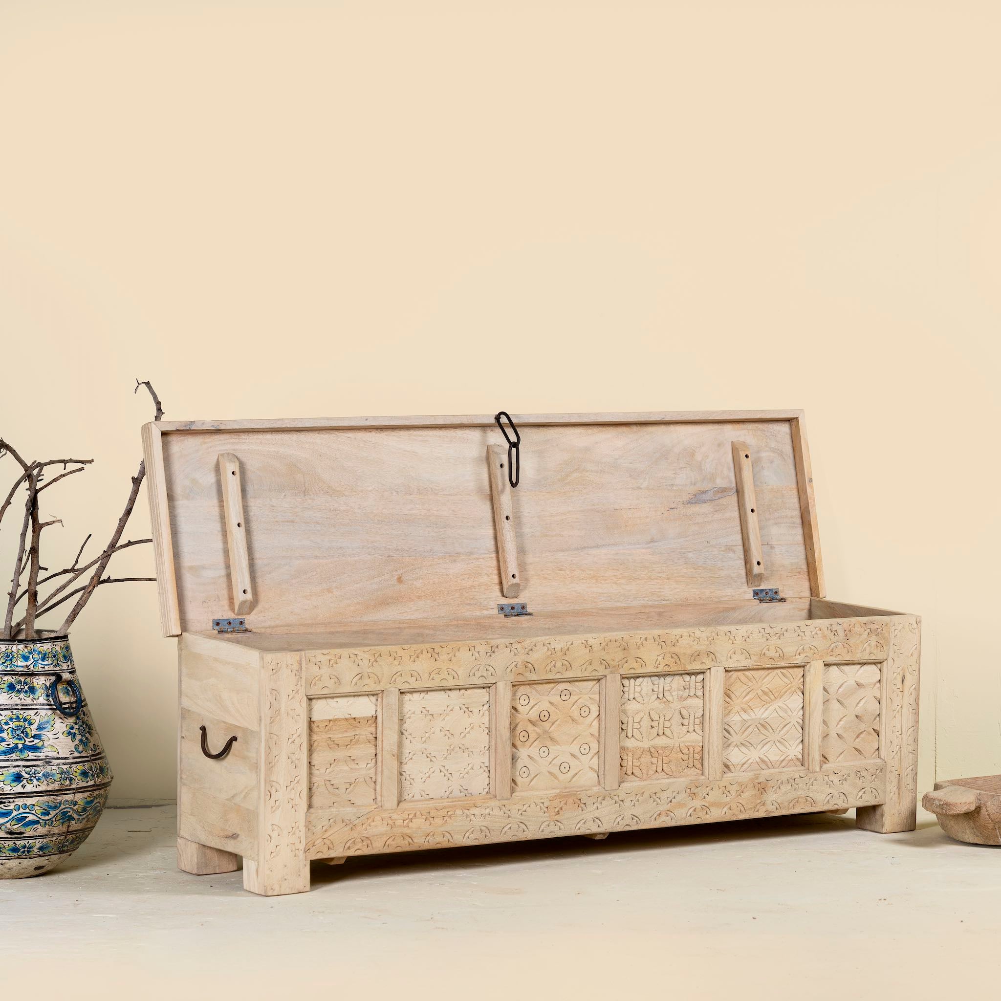 Open lid image of a Ibiza style carved mango wood chest with sandblasted finish and iron lock; 150 × 40 × 45 cm.