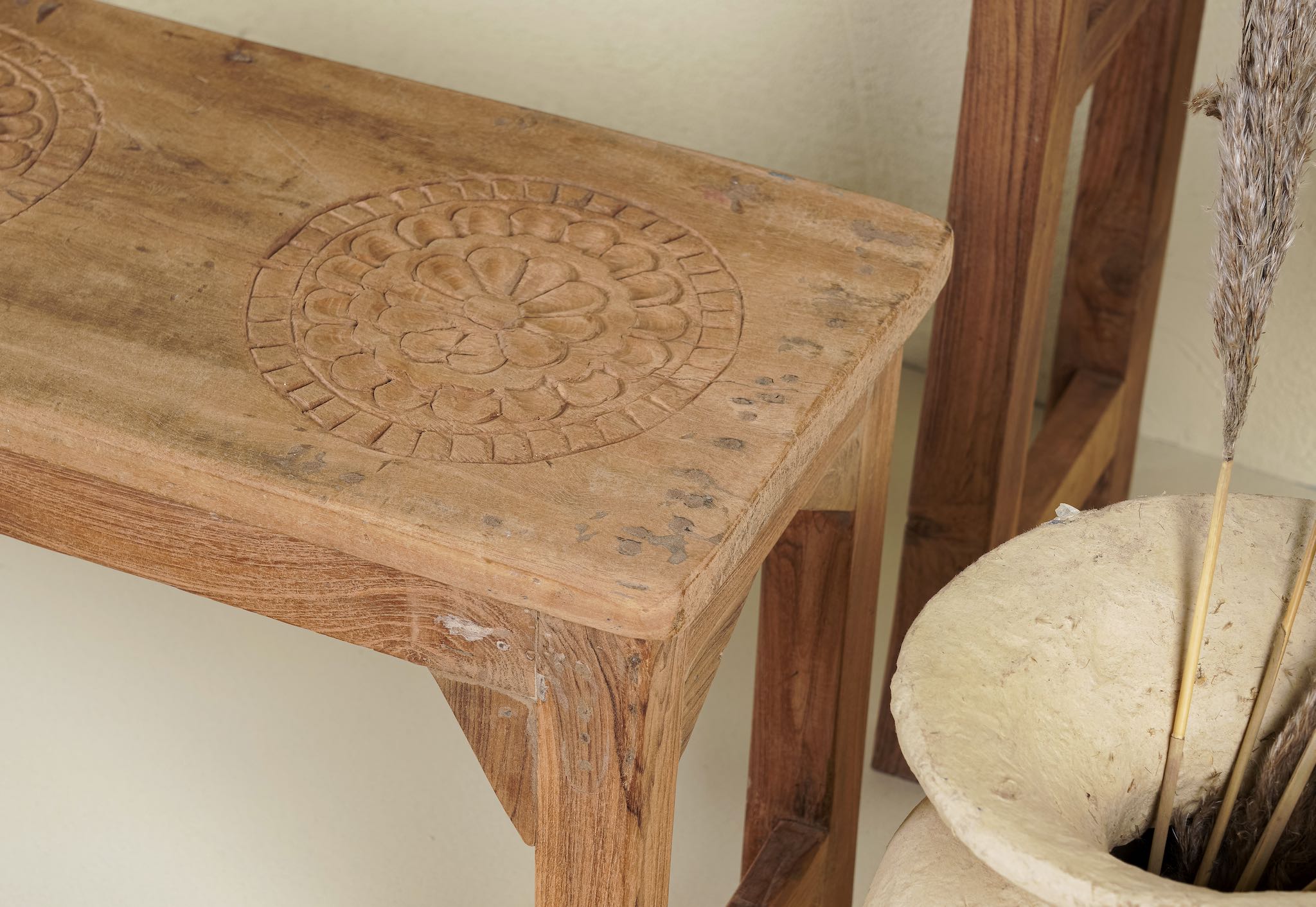 Close up image of the vintage school bench set Adil from India, crafted from old teak wood, featuring a simple, sturdy design with a long bench and matching table in a natural, weathered finish, styled in a neutral-toned interior with rustic decor accents.