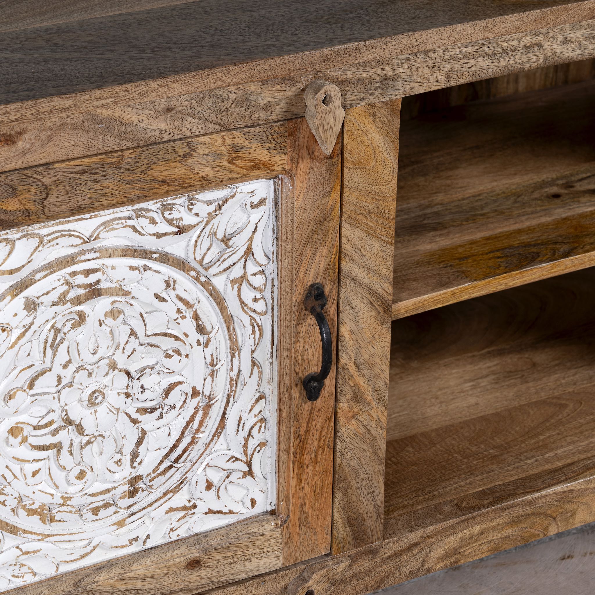 Close up image of a wood carved sideboard Alka, Indian furniture made from mango wood with floral carvings, whitewashed finish, 150 × 40 × 60 cm.