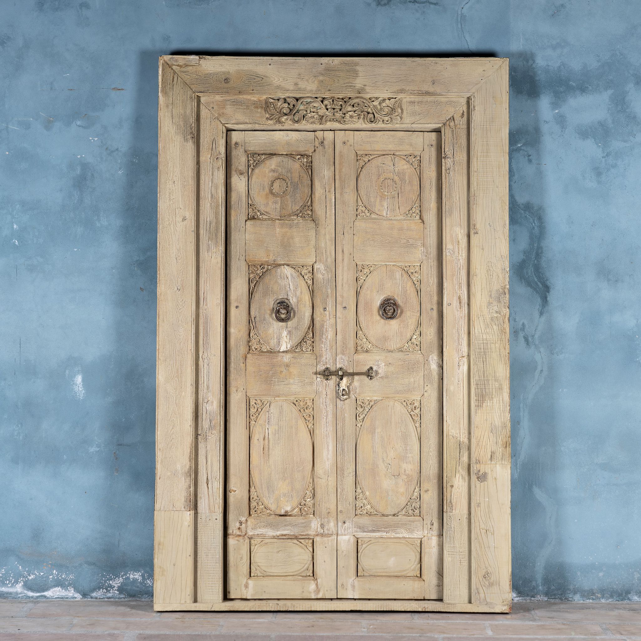 Antique Indian door Amaya made of reclaimed teak with brass fittings, hand-carved details, extended frame, usable as entrance or vintage wall panels, 161 × 20 × 250 cm.