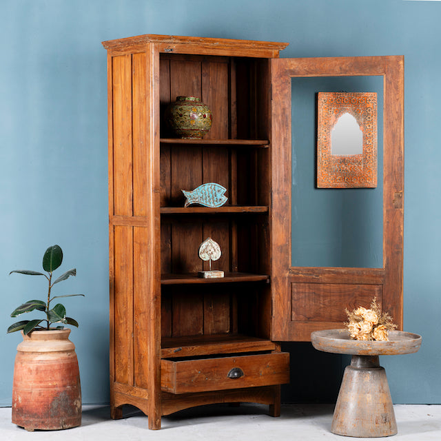 Side angle image with open door of an antique reclaimed teak wood display cabinet with glass door, honey wax finish, and lower drawer – unique furniture showcasing traditional Indian craftsmanship.