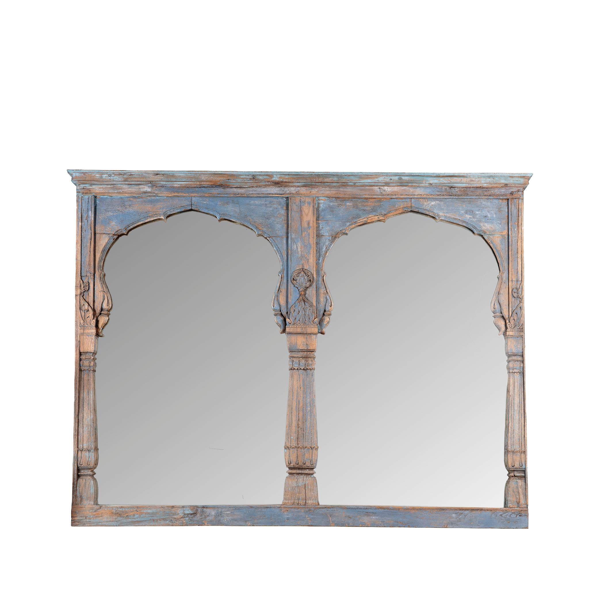 White background image of a Indian triple-arched teak wall mirror with indigo patina, perfect for vintage home decor or a boho chic living room.
