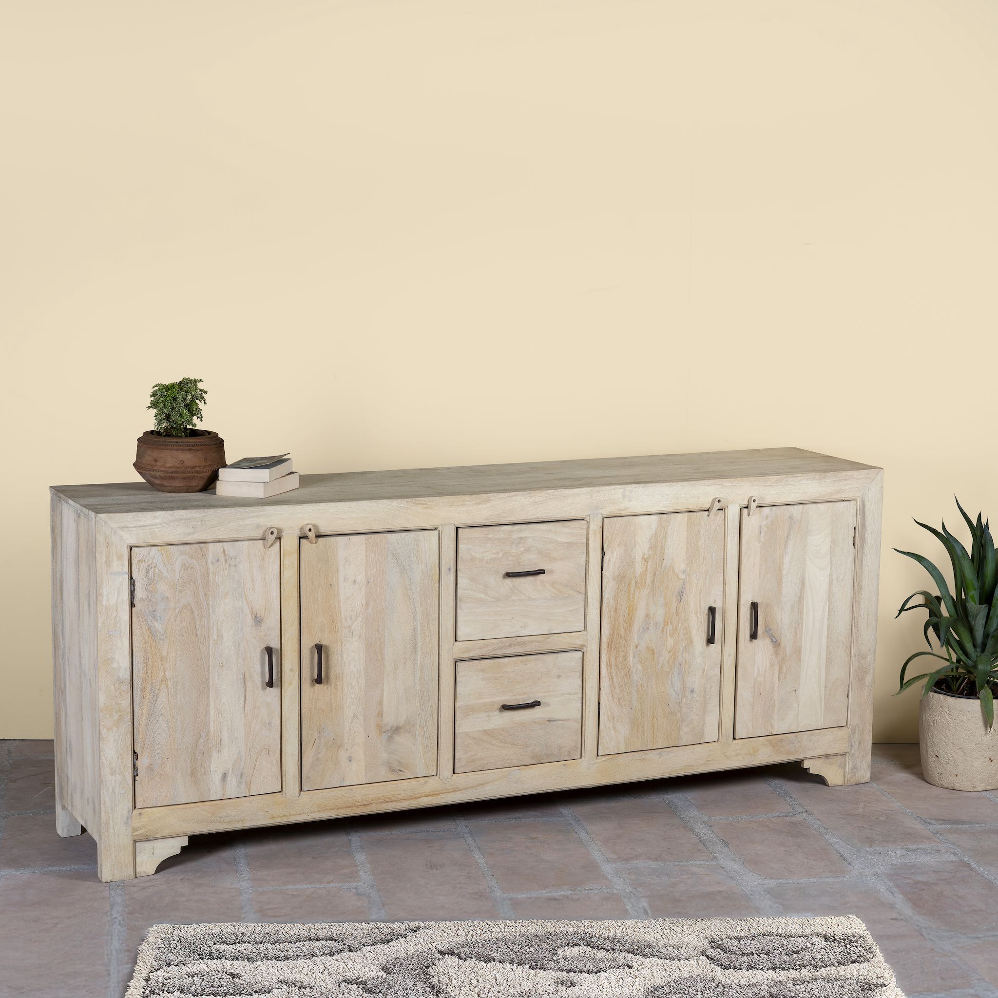 Wooden sideboard Ibiza style with doors and drawers against a beige wall.