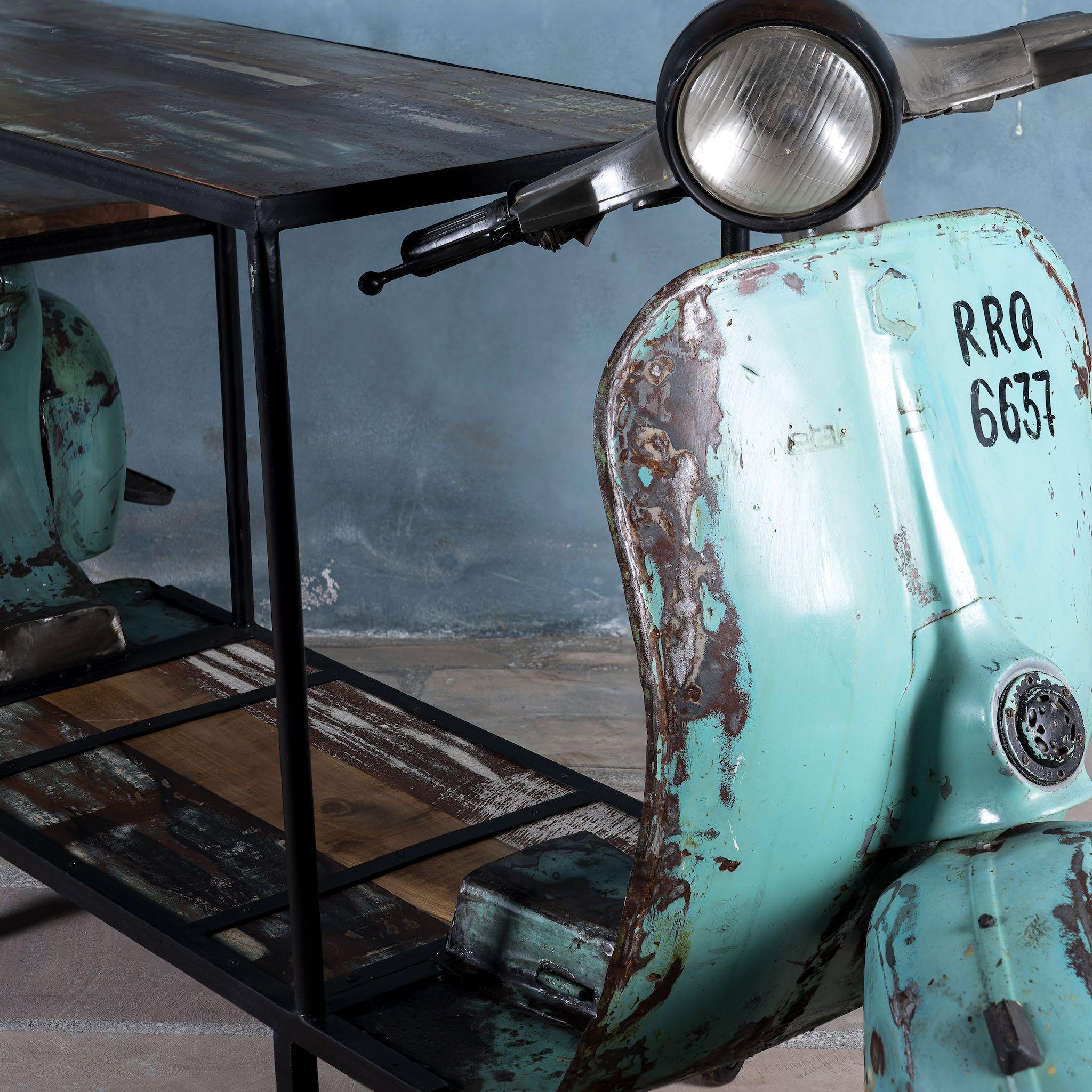 Close up image of a house bar crafted from a full vintage Indian Bajaj scooter with industrial metal frame and wooden shelves, featuring original patina and retro design elements.