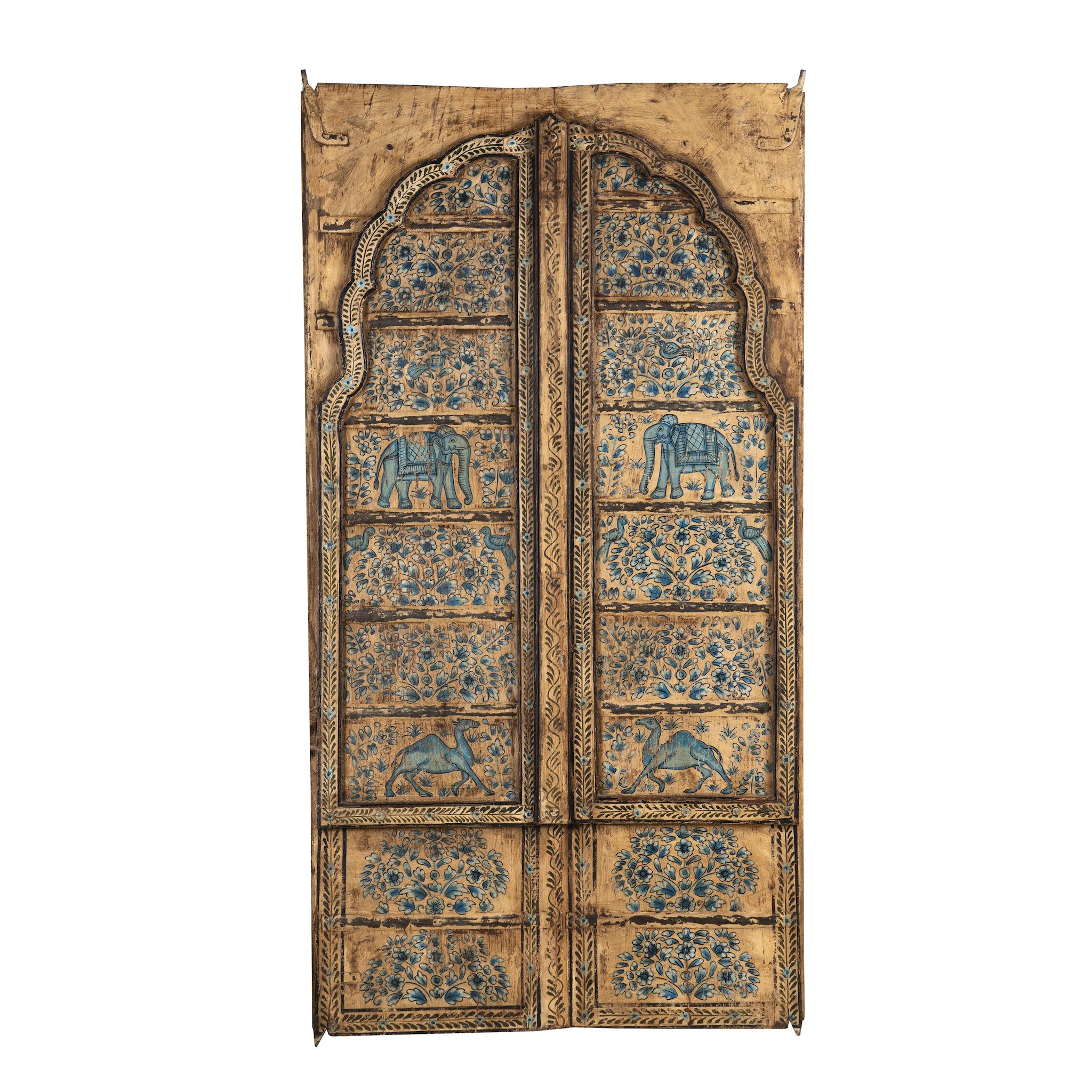 White background image of a hand-painted wooden wall panel made from an old window frame, featuring intricate blue floral patterns along with stylised animal motifs such as elephants and camels, set against a distressed golden-brown background with an arched top frame.