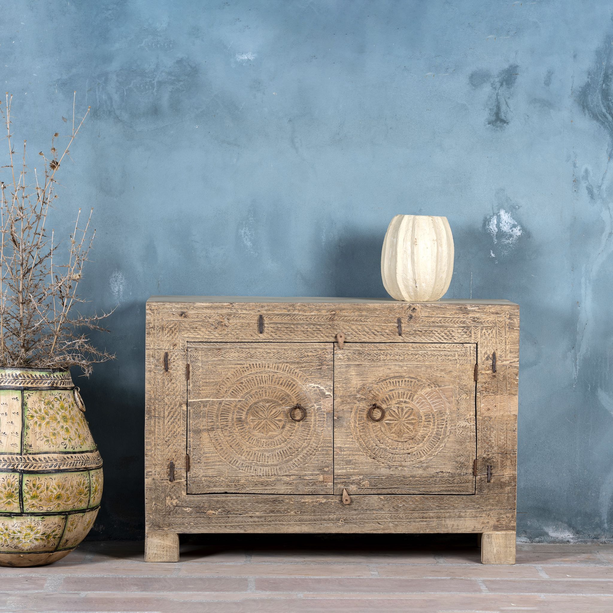 Sideboard with hand-carved teak wood front, sandblasted for a sun-worn finish — a unique piece in rustic Ibiza style with circular mandala carvings and iron ring handles.