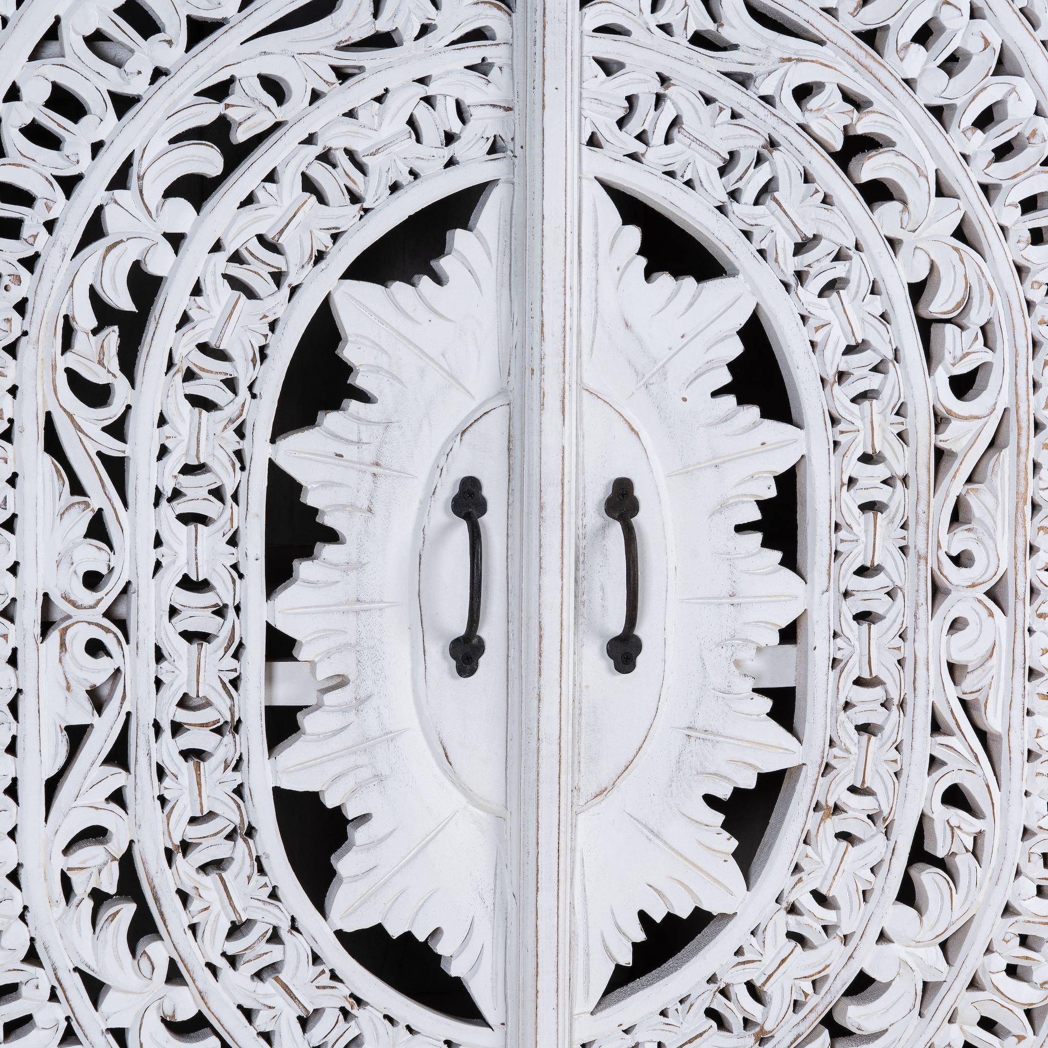Close up image of a hand-carved wooden wardrobe in white-wash finish, perfect for a boho chic living room or bedroom storage.