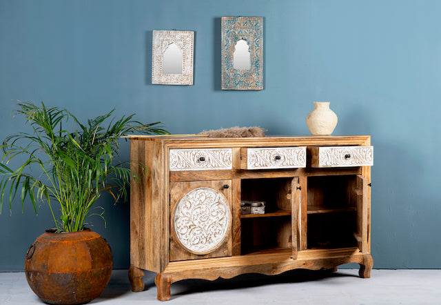 Side angle image with open doors of a hand carved wooden sideboard made from mango wood with floral carvings and curved base, mango wood furniture with storage, 150 × 40 × 95 cm.