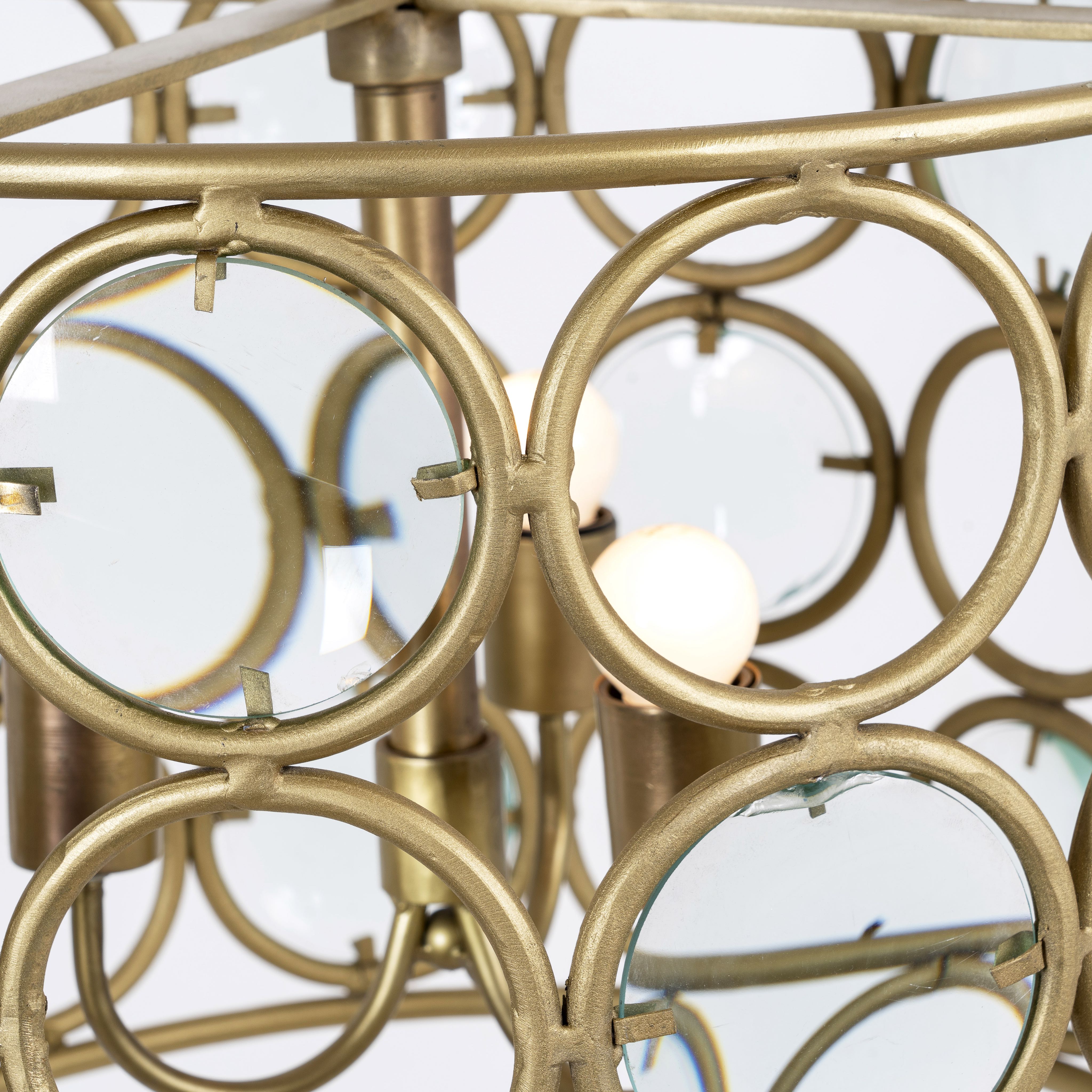 Close up image of a round unique pendant light with shiny brass-plated iron frame and magnifying glass inserts – vintage lighting with elegant three-light design for kitchens, dining areas, or living rooms.