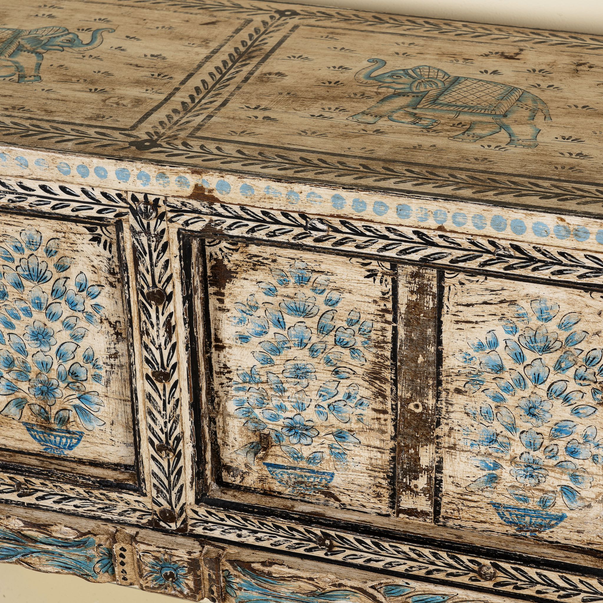 Close up side image of a hand painted console table in reclaimed teak with floral motifs and antique distressed finish, 197 × 40 × 82 cm.
