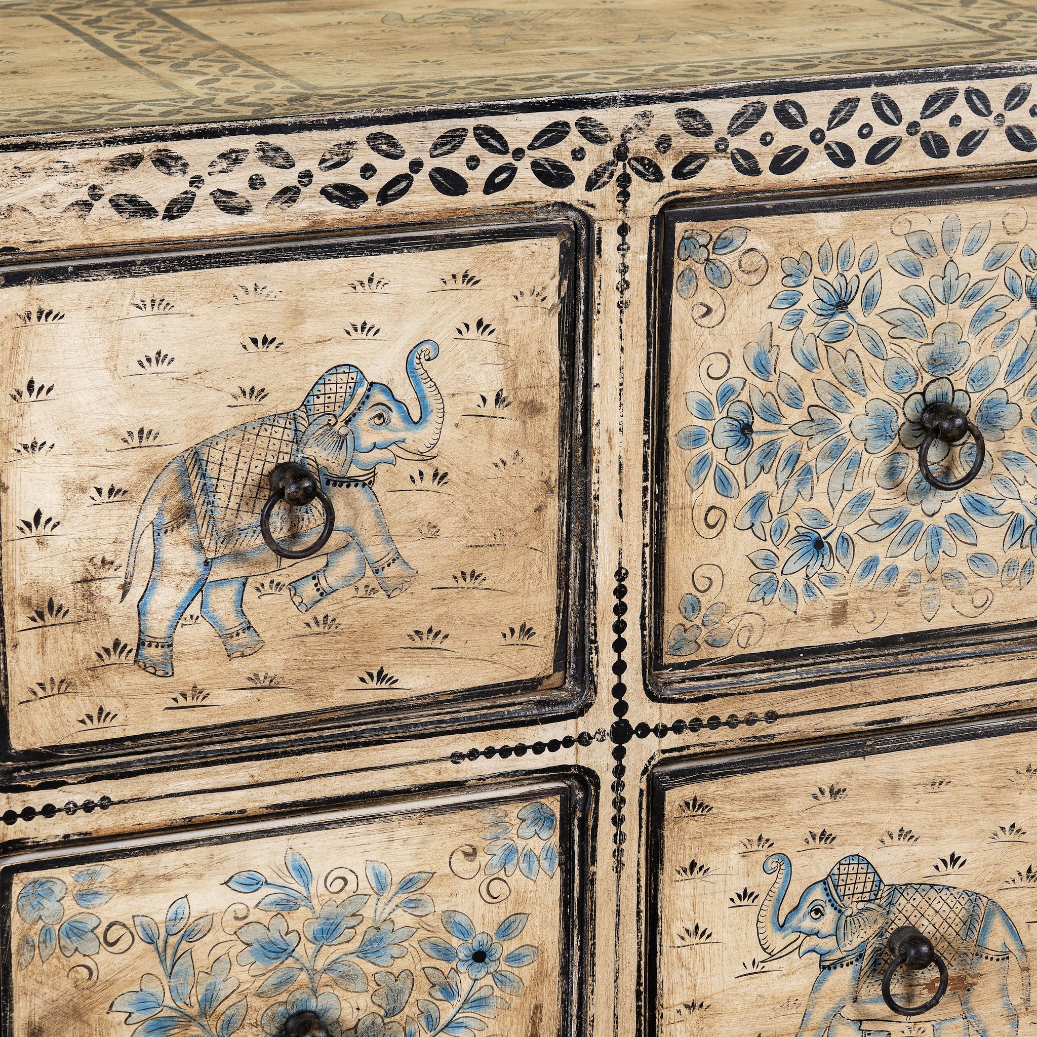 Close up image of a hand painted mango wood chest of 10 drawers with elephant and floral motifs; hand painted furniture for a boho chic living room, 200 × 41 × 85 cm.