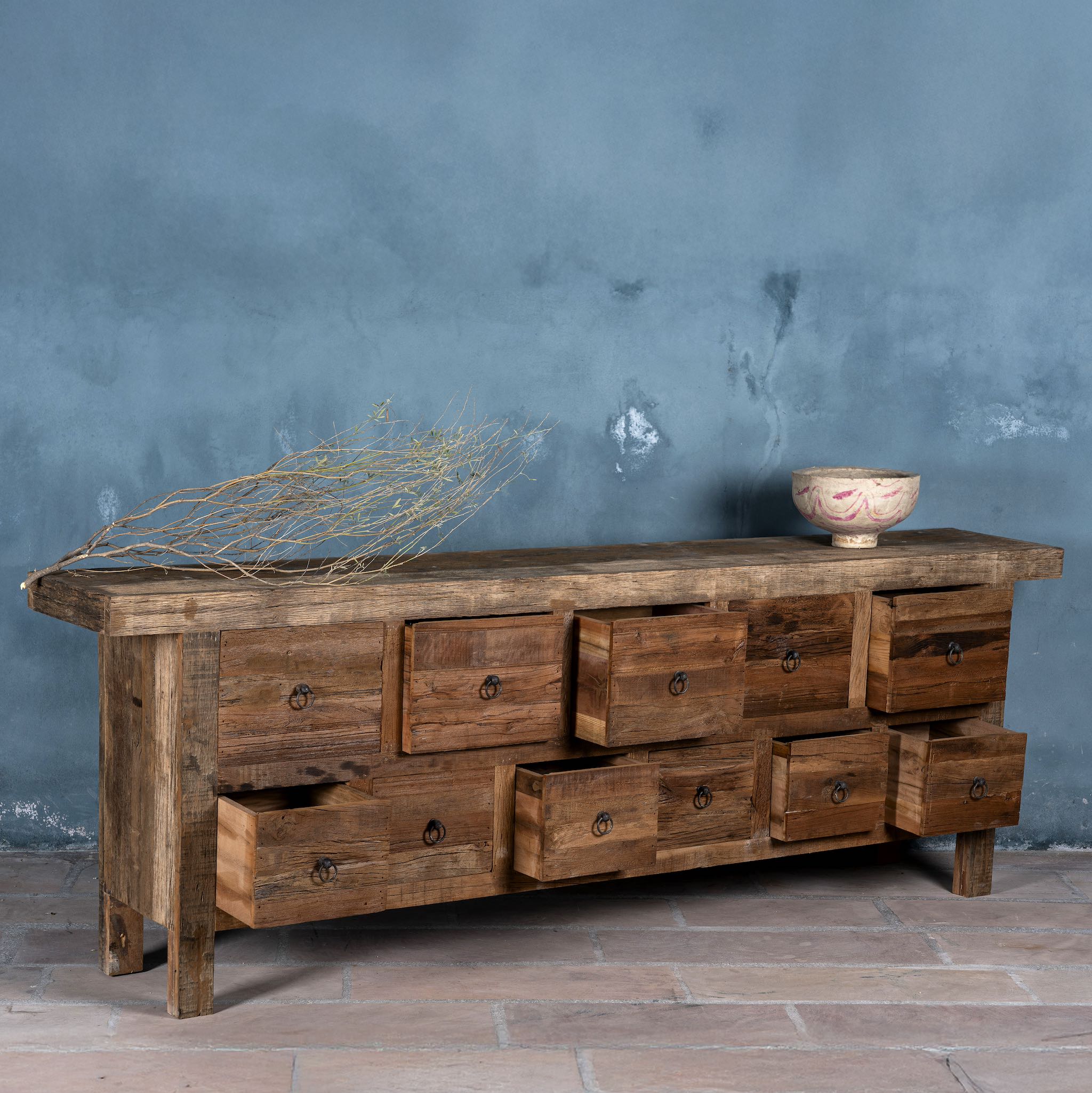 Side view image with open drawers of a reclaimed wood console table with rustic finish, multiple drawers, and iron ring pulls; sustainable furniture with driftwood charm, 250 × 40 × 85 cm.