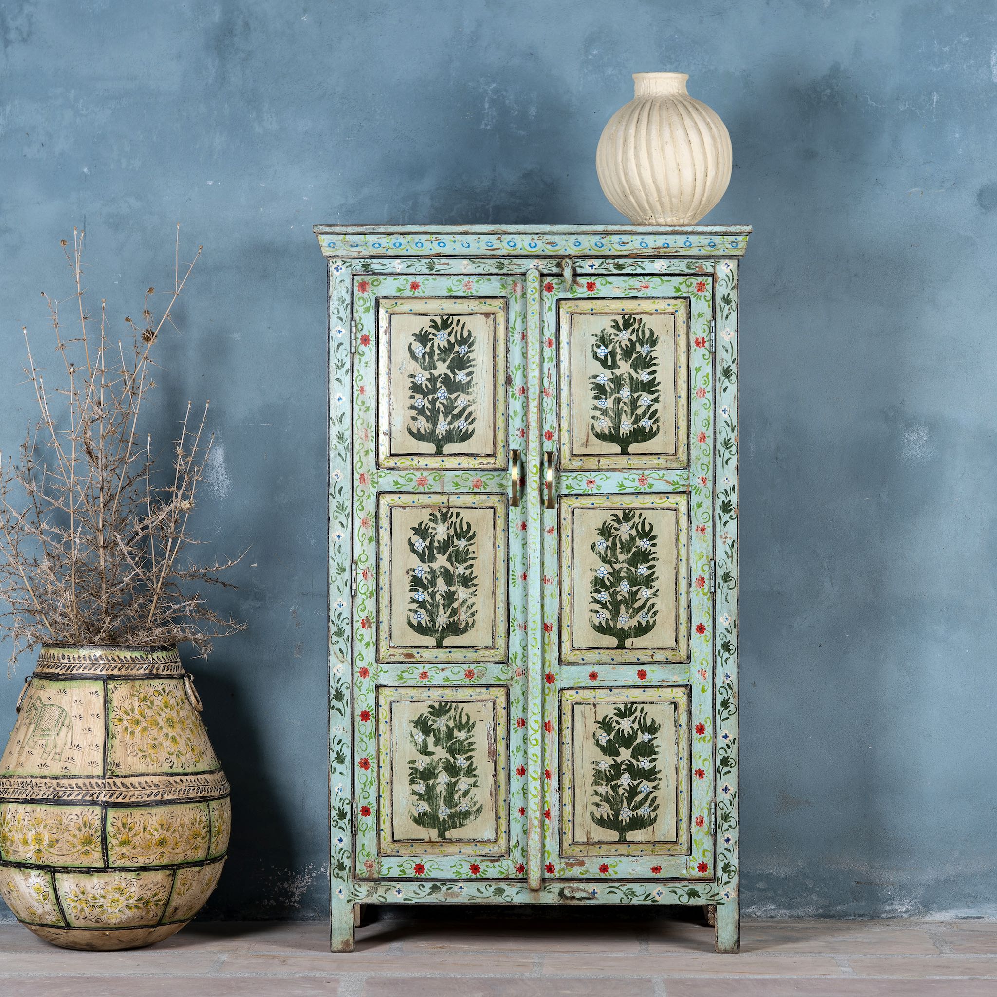 Vintage cabinet made from reclaimed wood, featuring hand-painted floral and tree motifs in vibrant green, red, and turquoise tones for a joyful, artistic touch.