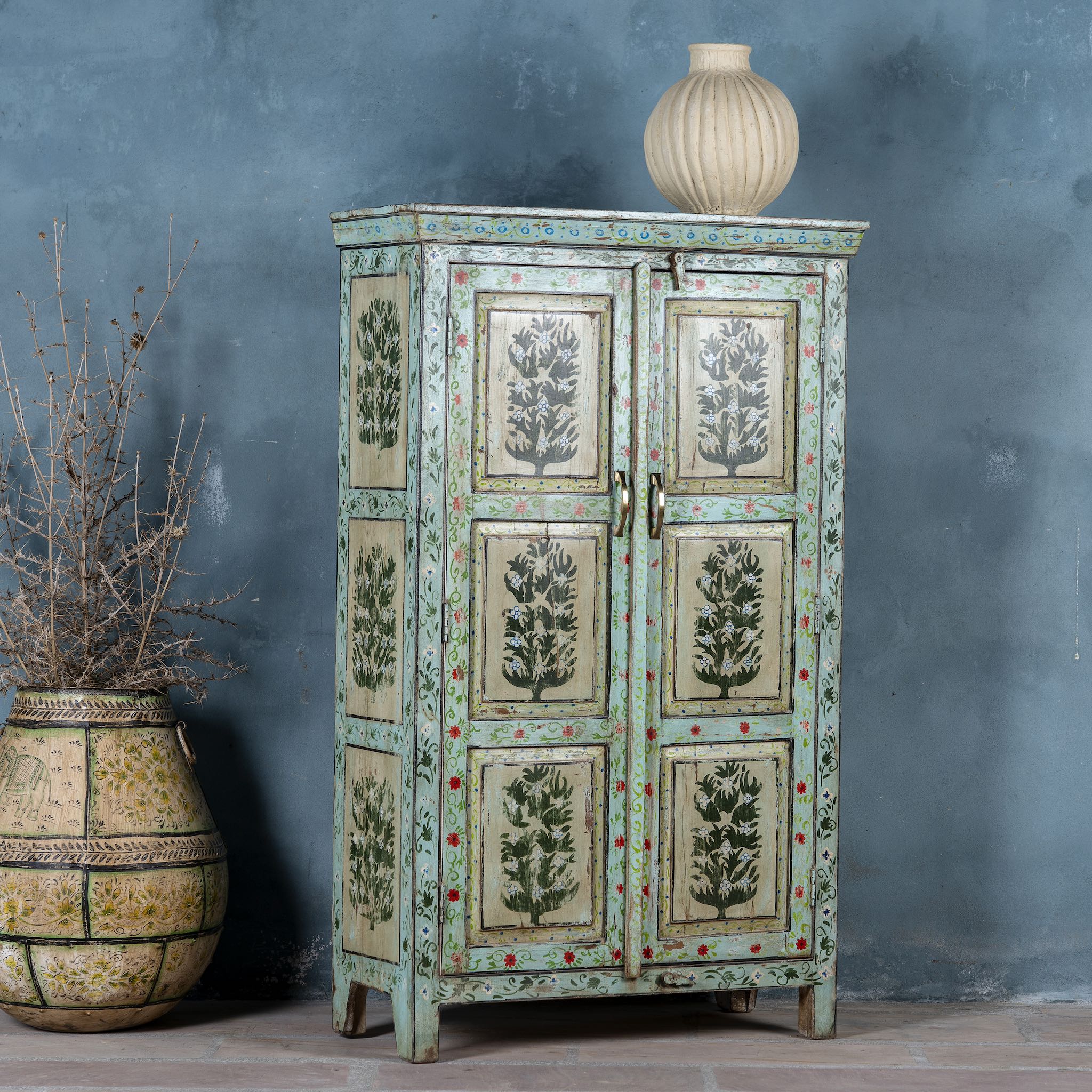 Vintage-style cabinet with botanical designs on a gray background