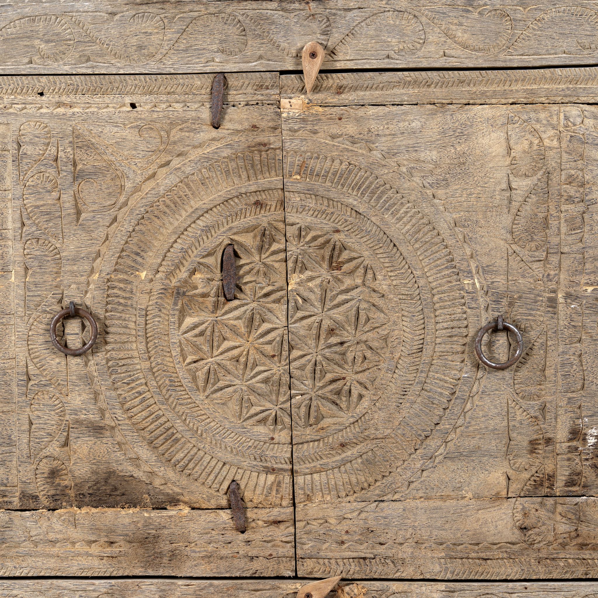 Close up image of a reclaimed wood sideboard made from antique teak doors with carved detailing; teak furniture, 134 × 37 × 82 cm.