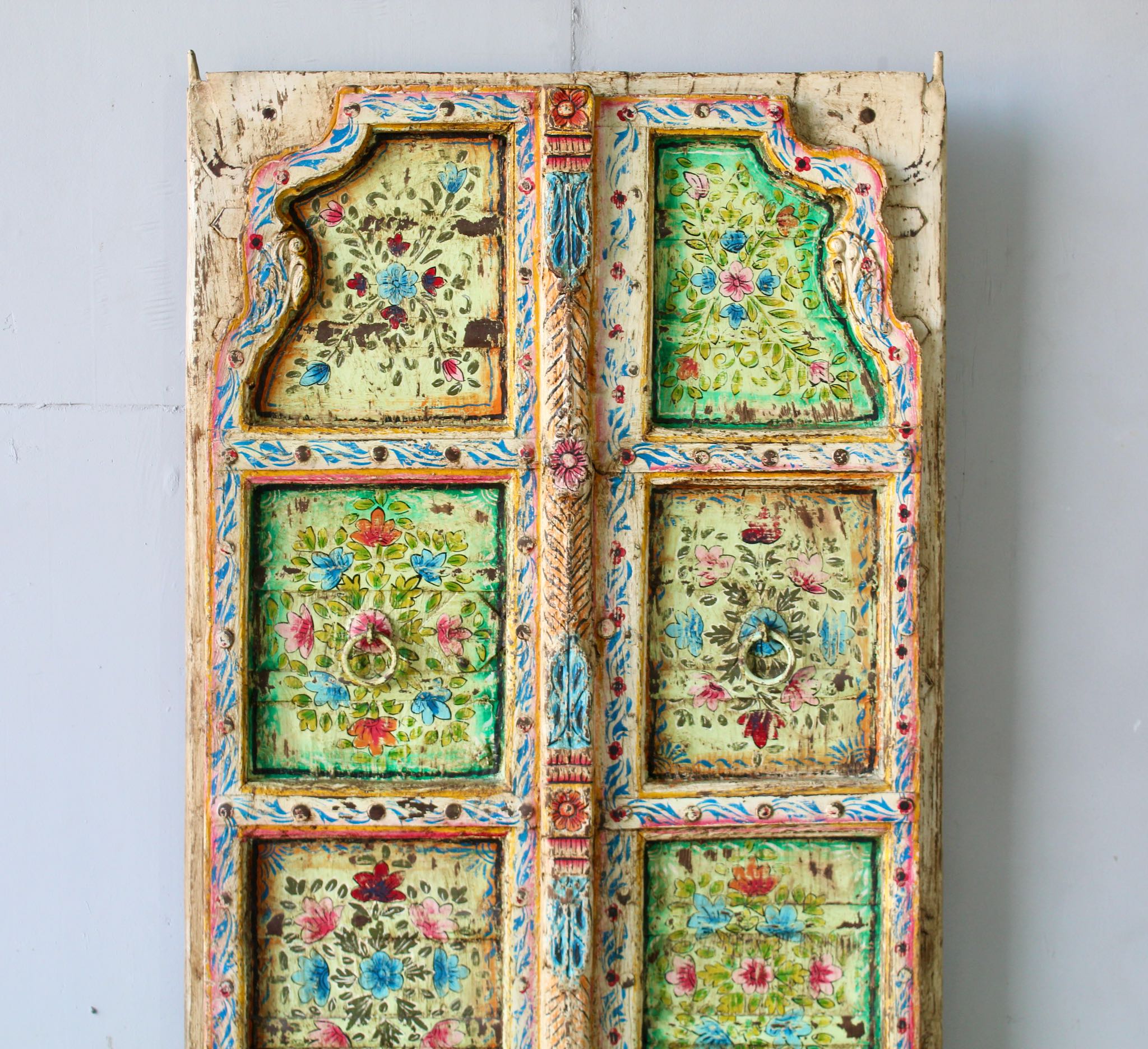 Close up image of a and-painted Indian antique door panel with floral motifs, reclaimed teak wood, vintage wall panels and vintage home decor.