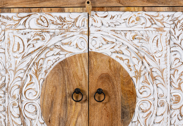 Close up image of a carved wood furniture cabinet made from mango wood with floral whitewashed doors, 90 × 40 × 90 cm.