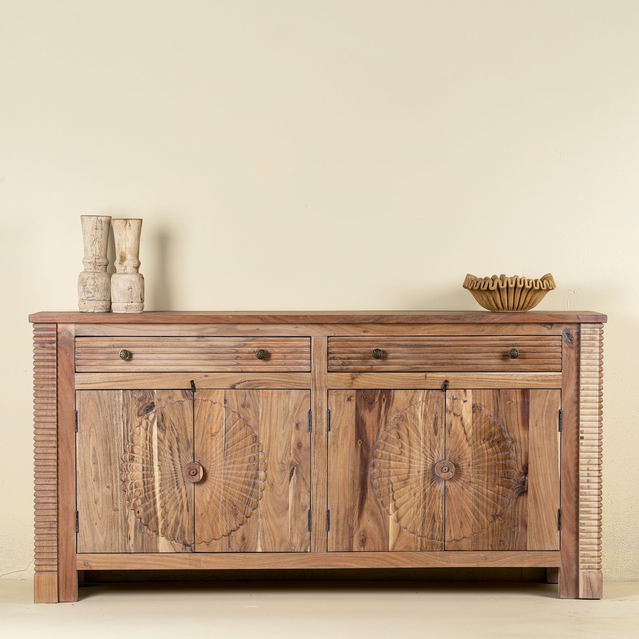 Carved acacia wood sideboard with four doors, two drawers, brass handles, and tapered legs; artisanal acacia wood furniture, 180 × 40 × 90 cm.