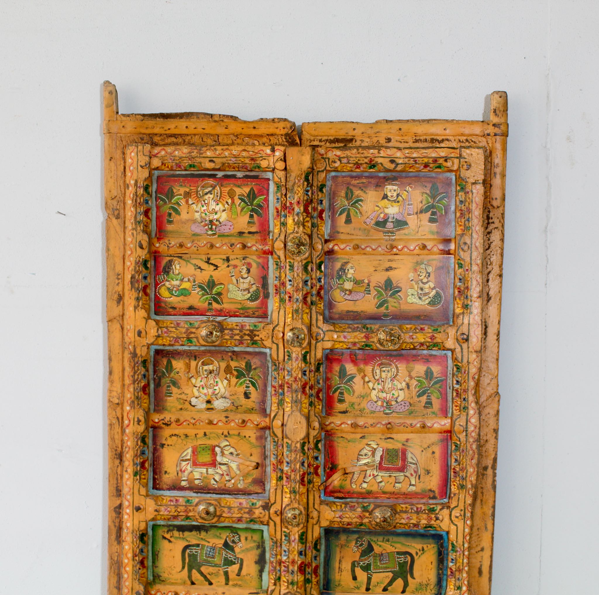 Close up image of a hand-painted Indian antique teak wood door with folk and mythological motifs, vintage wall panels for eclectic and vintage home decor.
