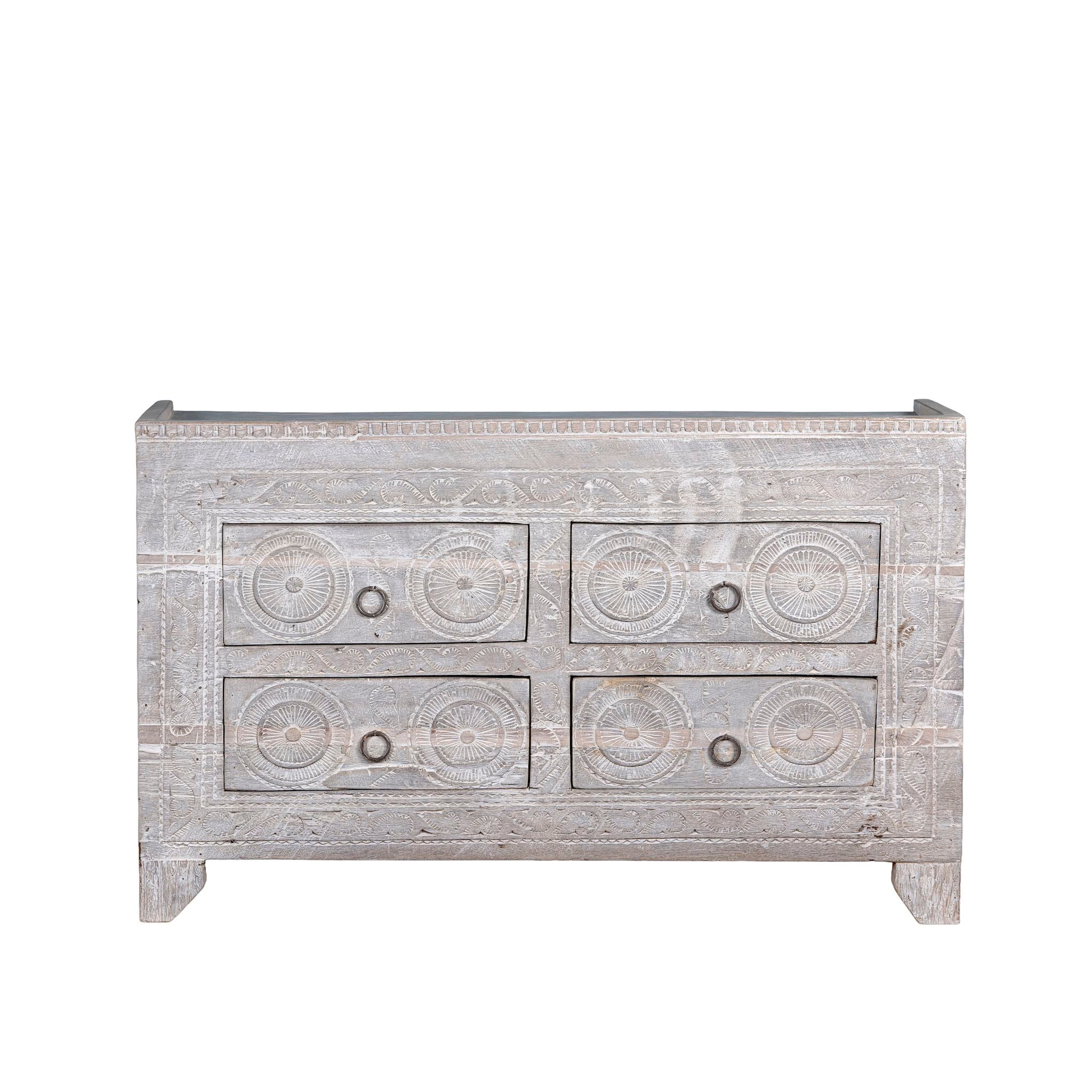 White background picture of a Ibiza style sideboard with six drawers, made from hand-carved wood in a whitewashed finish, featuring circular mandala motifs and rustic iron handles.