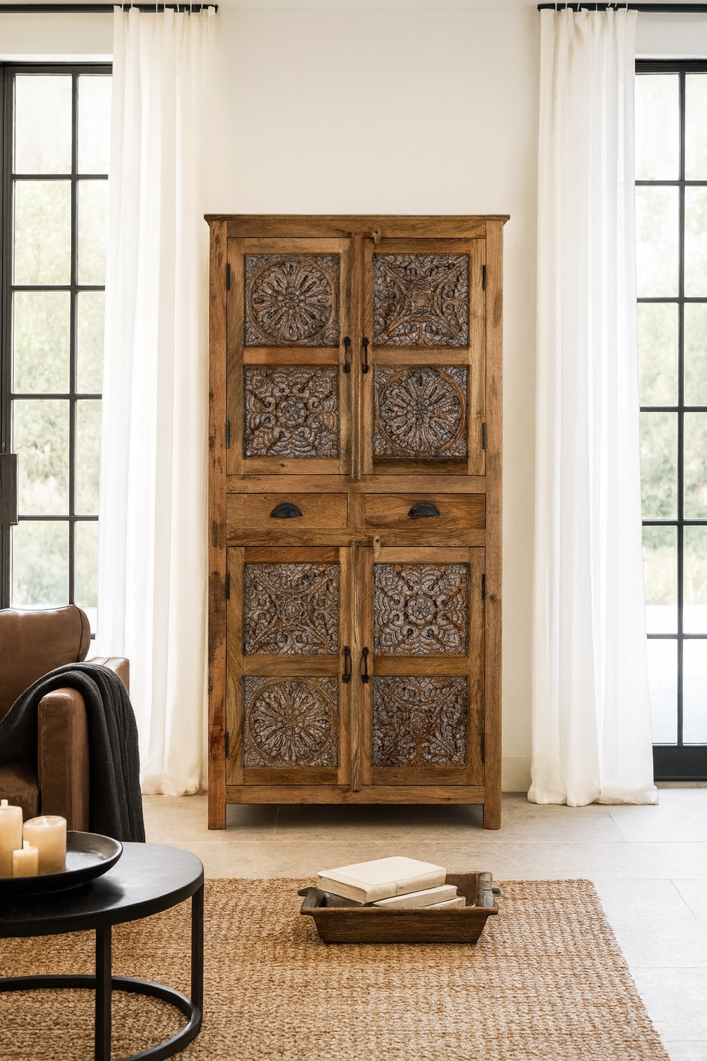 Lifestyle image of a hand-carved mango wood cabinet with floral motifs and silver finish – bedroom furniture with rustic charm and artisanal detail.