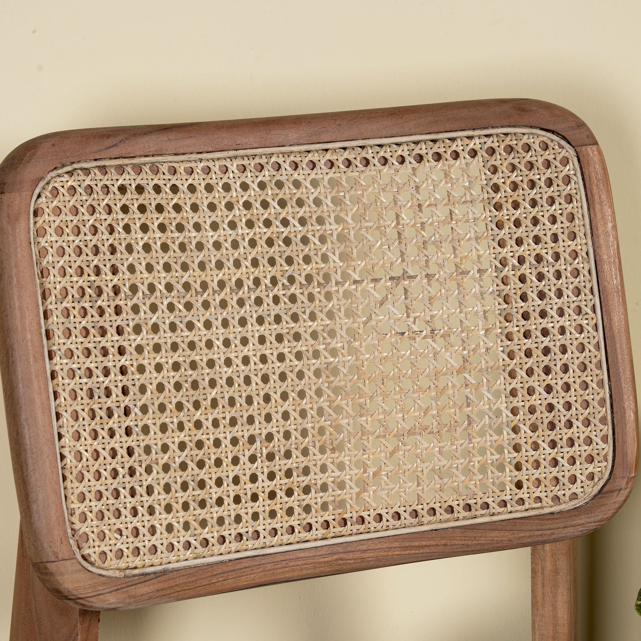Close up image of an acacia wood chair with woven rattan backrest and solid wooden frame; wooden armchair for dining or living rooms, 45 × 45 × 85 cm.