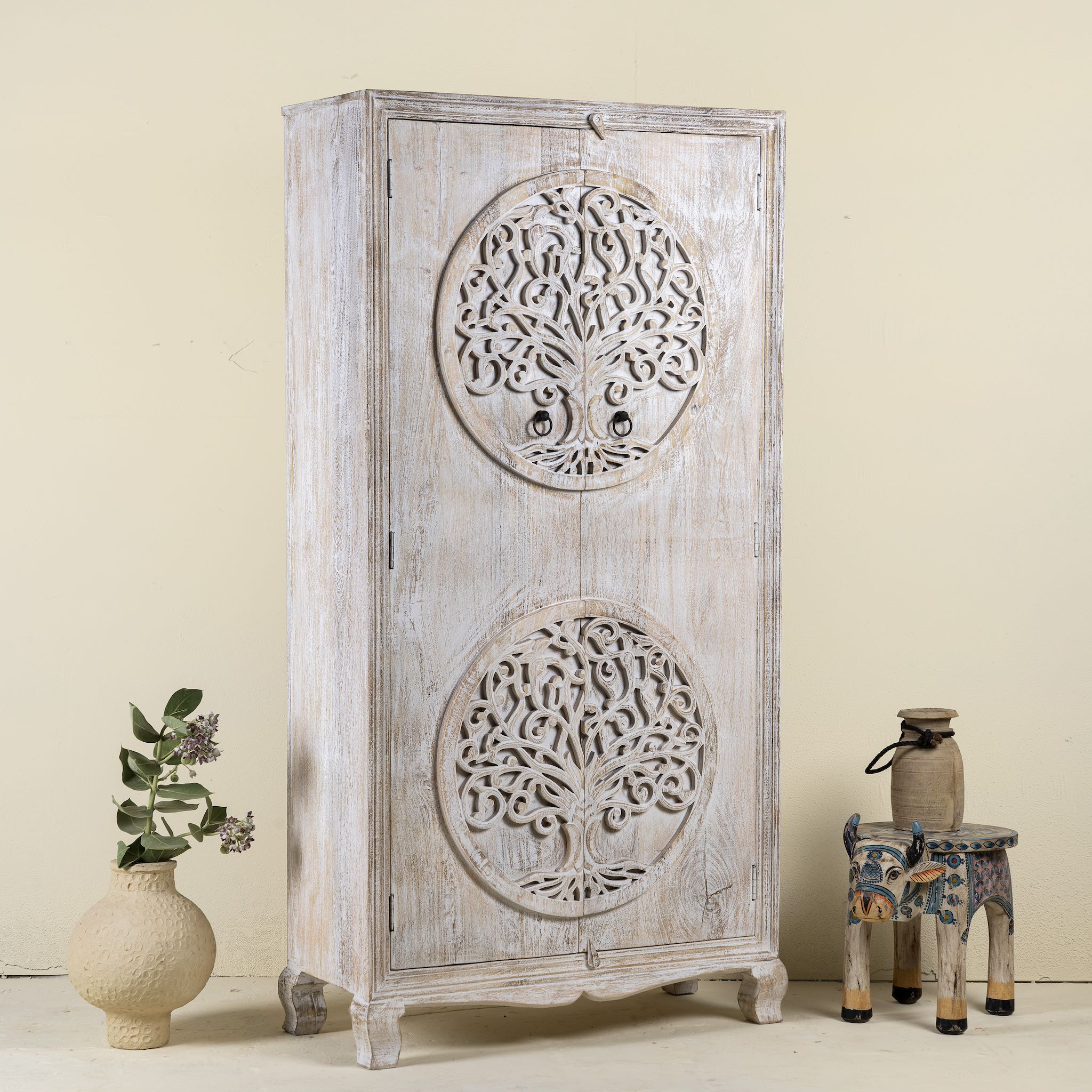 Side angle image of a hand-carved mango wood wardrobe with Tree of Life design, distressed finish, ideal for bohemian interiors, 90 × 40 × 180 cm.