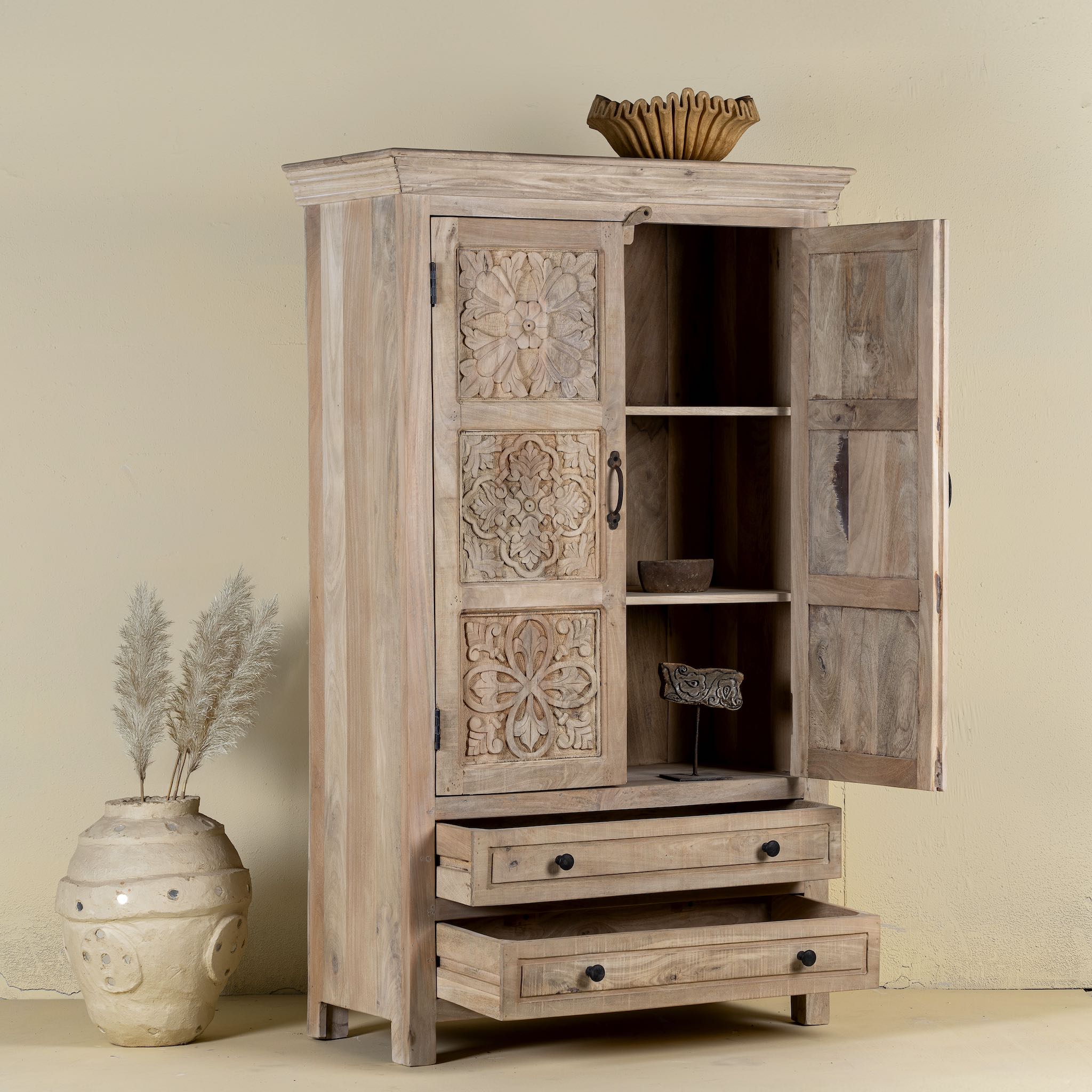 Side angle image with open doors of a hand-carved mango wood cabinet with floral and geometric detailing – carved wooden furniture and elegant bedroom storage by Om Home & Garden.