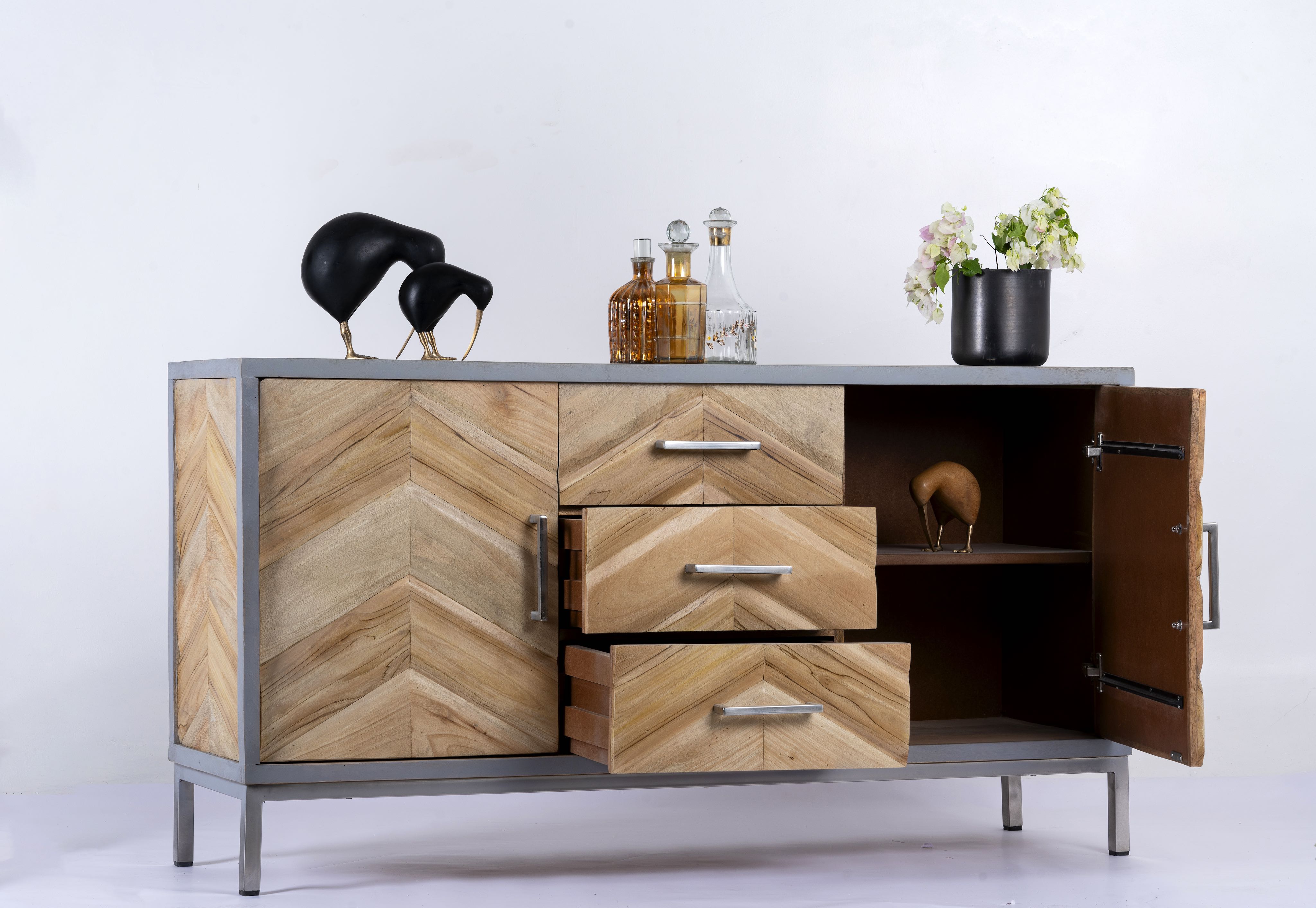 Side angle image with open door of a handcrafted teak wood sideboard with parquet design and grey stainless steel frame—artisanal furniture ideal for a modern living room.