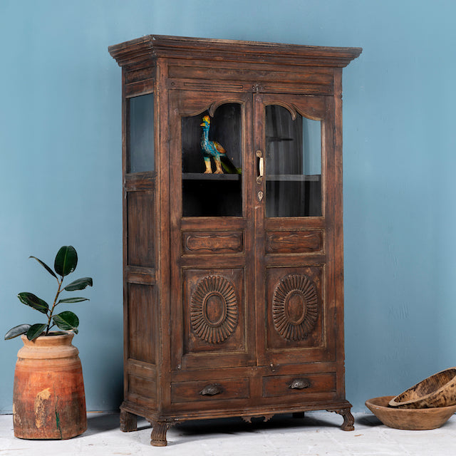 Side angle image of a reclaimed teak wood display cabinet with glass doors – unique Indian furniture with natural wax finish and timeless craftsmanship.