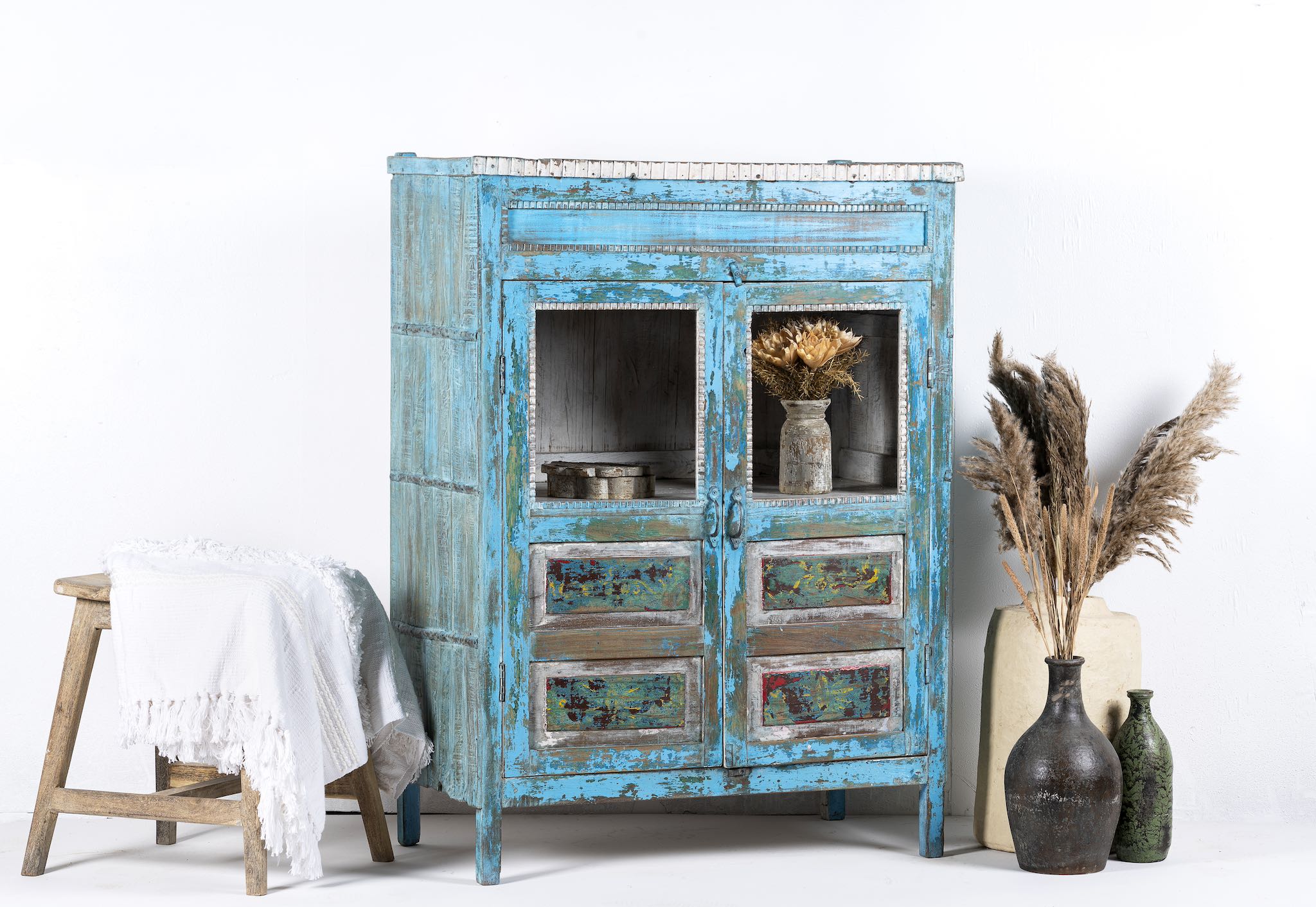 Side view of a blue vintage glass door cabinet made of reclaimed wood with added decoration.