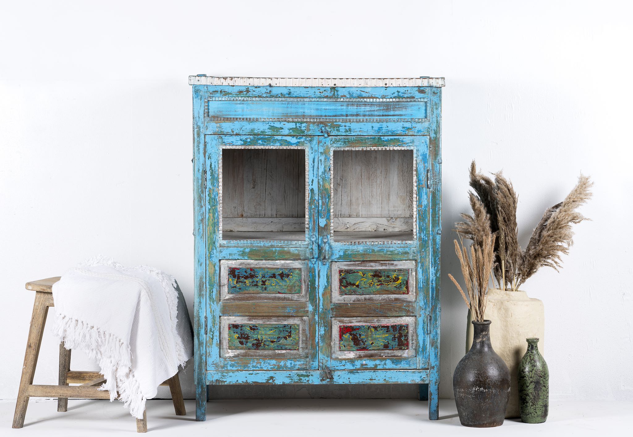 Front view of a blue vintage glass door cabinet made of reclaimed wood with added decoration.