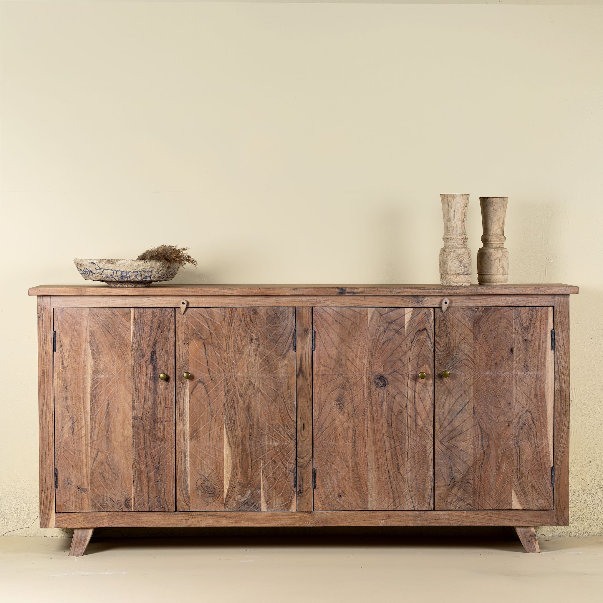 Front view of a sideboard with modern appeal made of acacia wood with brass fitted doorknobs and 4 doors.