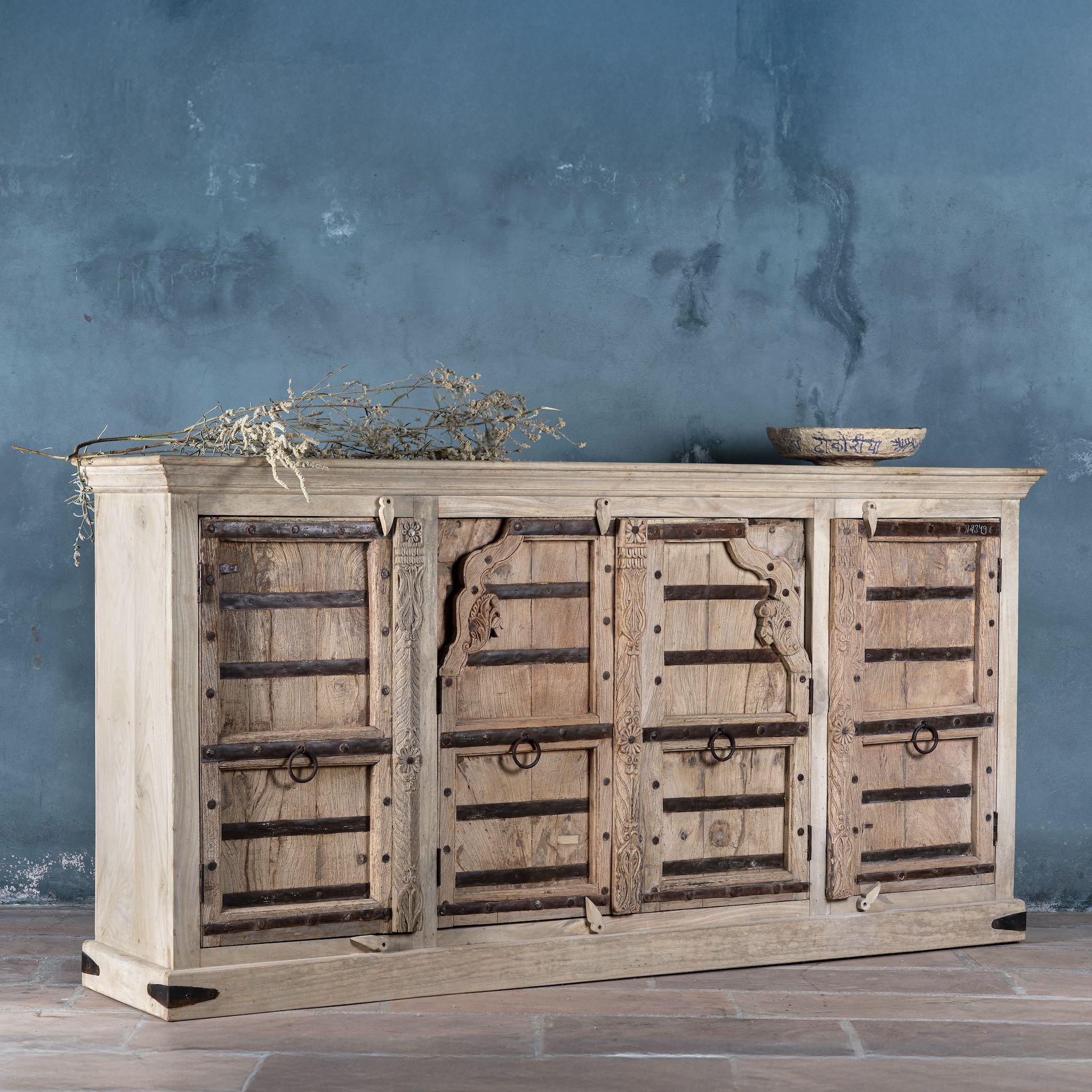 Sideview of a reclaimed teak furniture sideboard with antique Indian doors, old door cabinet with hand-carved details and iron accents, 220 × 45 × 110 cm.
