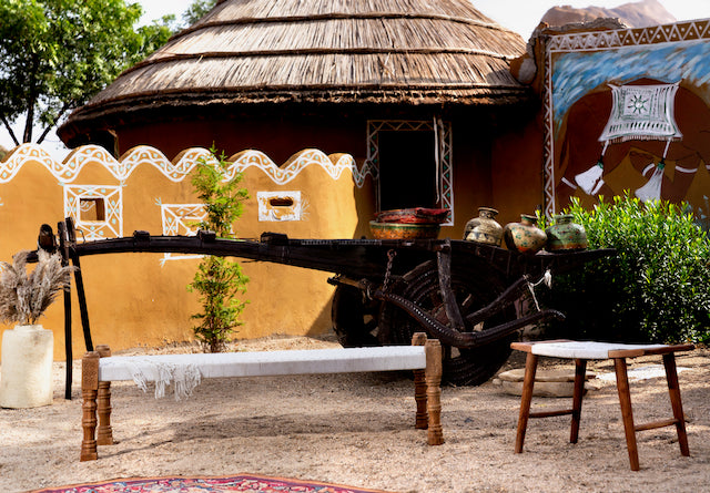 Low mango wood bench with handwoven cotton seat and recycled wood frame; Indian daybed-style, 120 × 45 × 20 cm.
