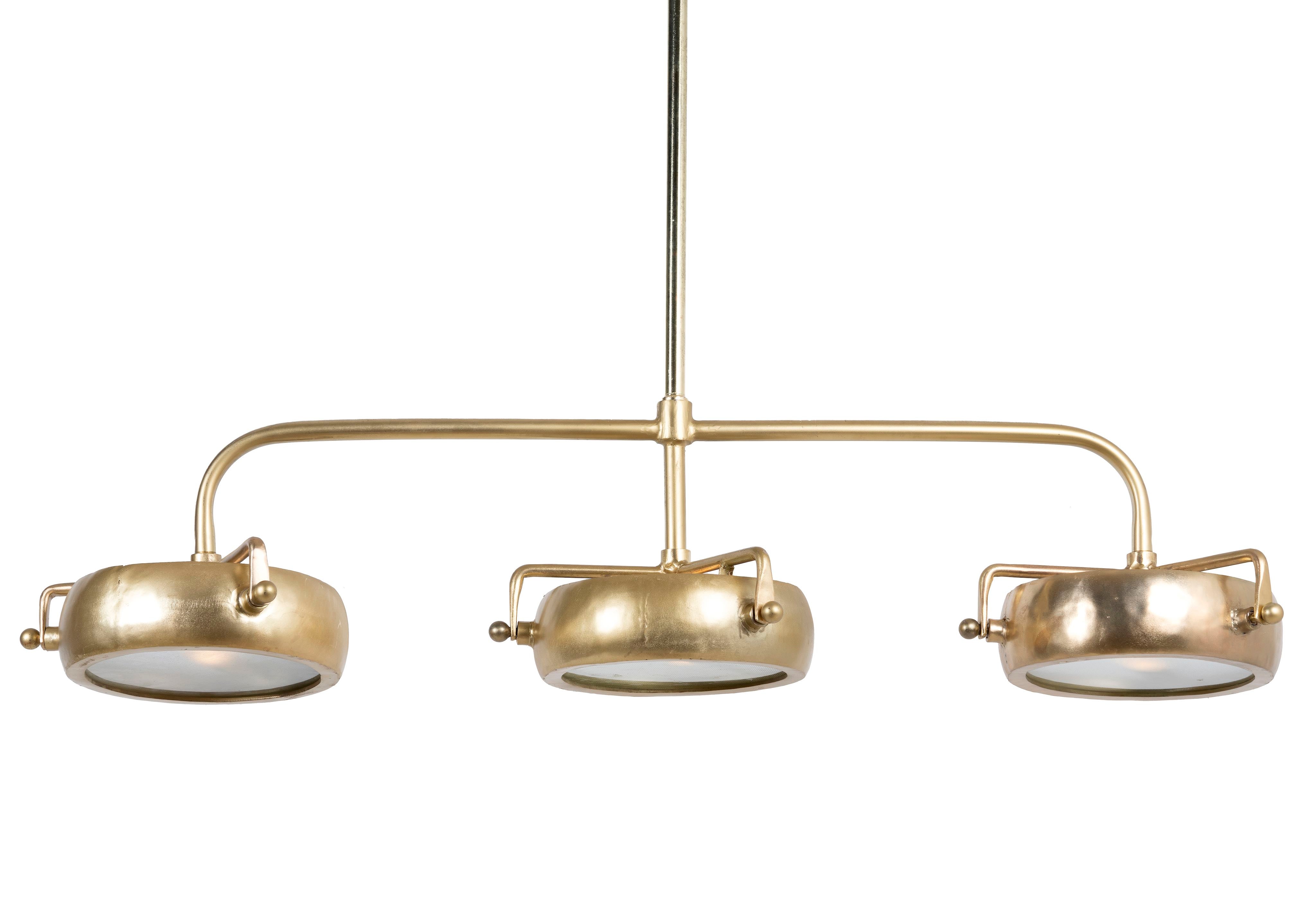 A retro pendant light with three gold-colored light fittings, featuring a brass-plated iron structure and clear glass lampshades.