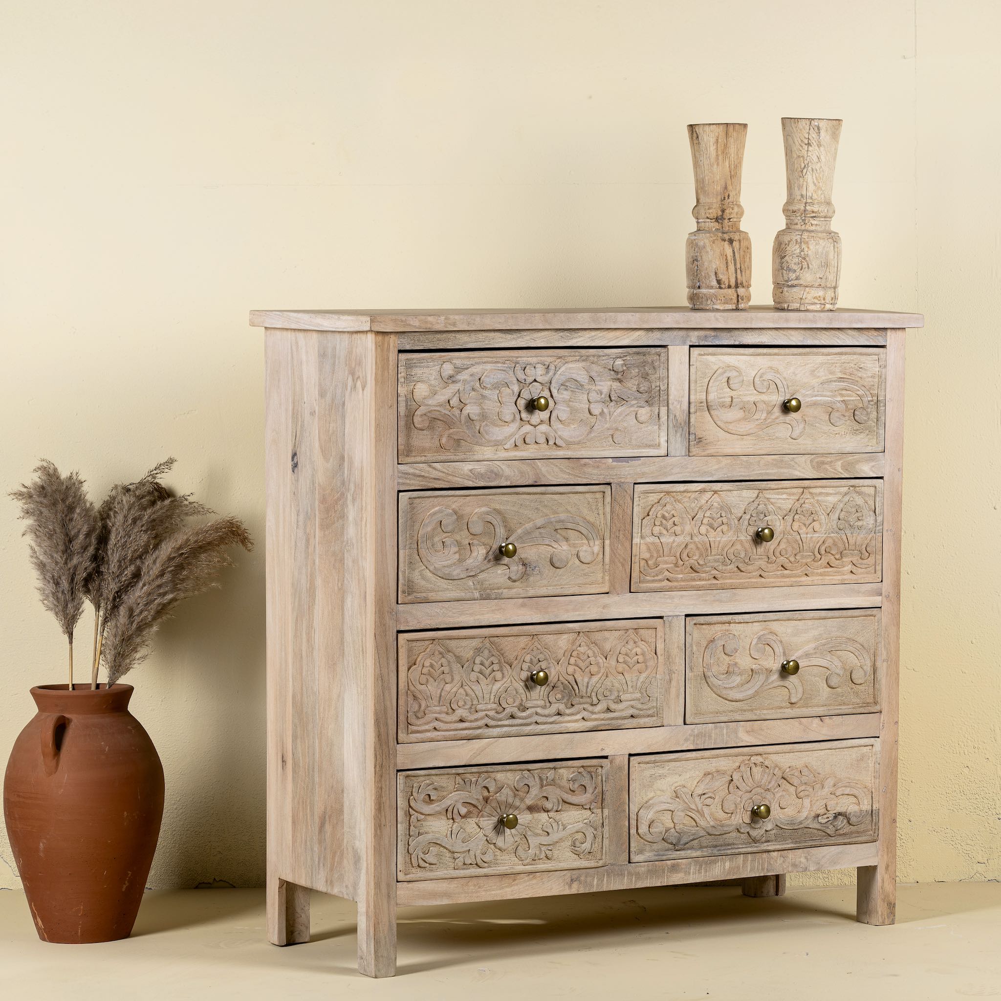 Side angle image of a carved mango wood cabinet with drawers and one door, made from reclaimed teak, 100 × 40 × 100 cm.