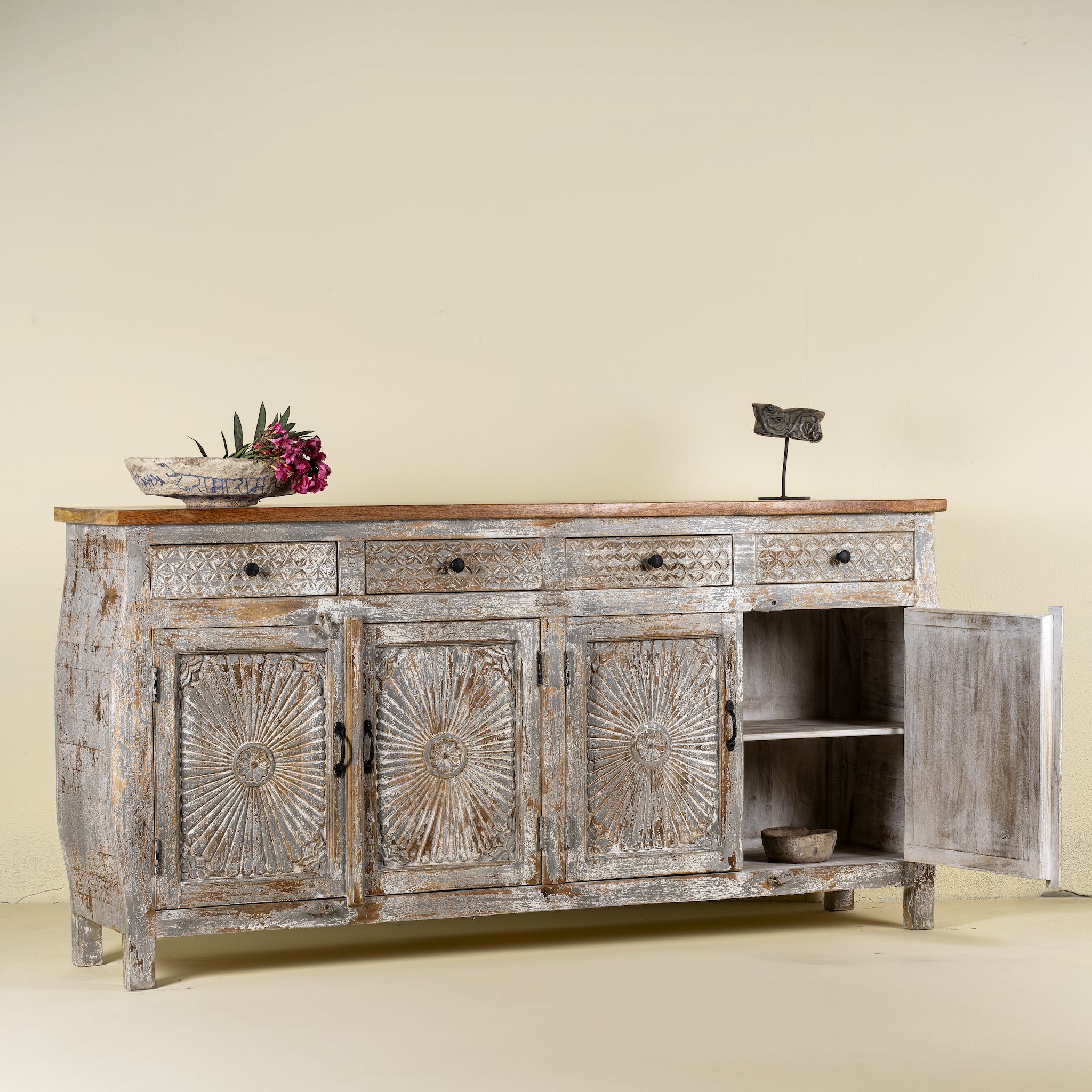 Open door image of a living room furniture sideboard made from hand-carved mango wood, vintage style furniture with sunburst patterns and distressed finish, 180 × 40 × 90 cm.