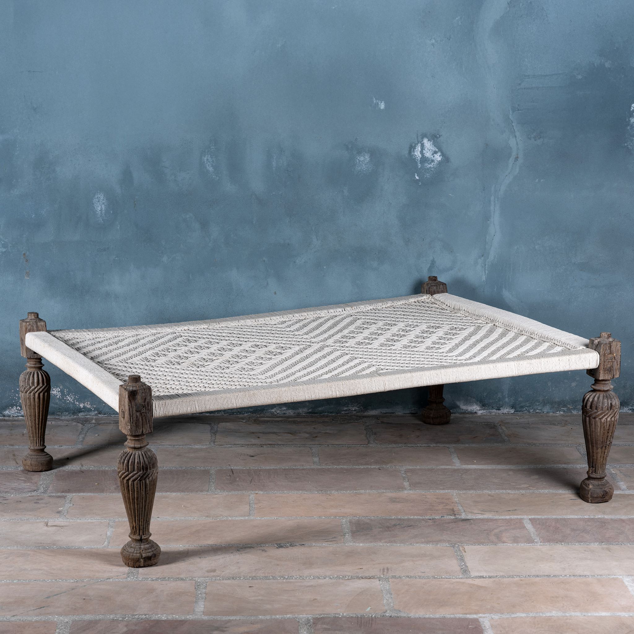 Front view of a handwoven Indian Charpoi bed with reclaimed teak frame and carved legs; perfect for Indian home decor, 174 × 122 × 60 cm.