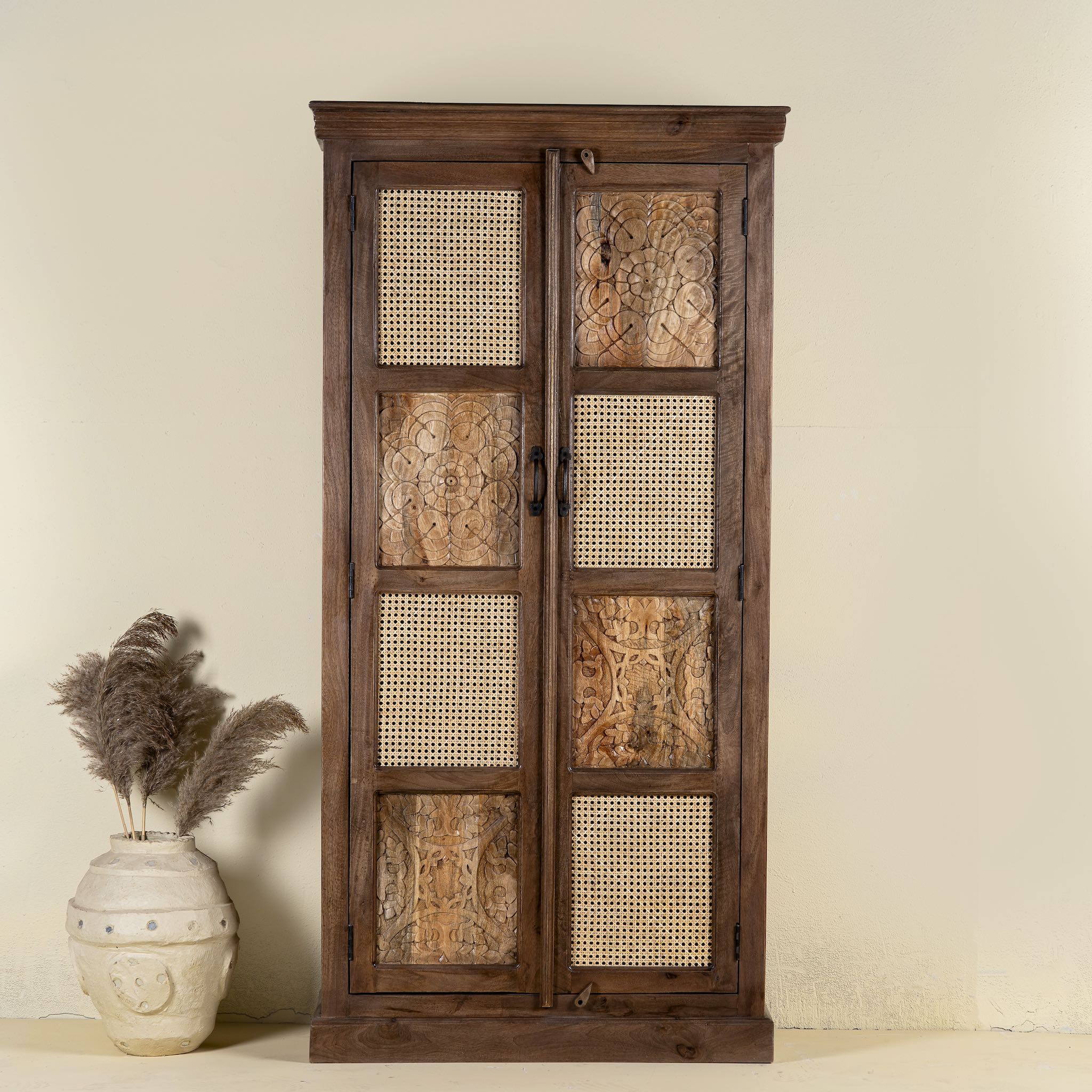 Front view of a hand carved mango wood cabinet with floral design, 2 doors and one drawer in vintage design.