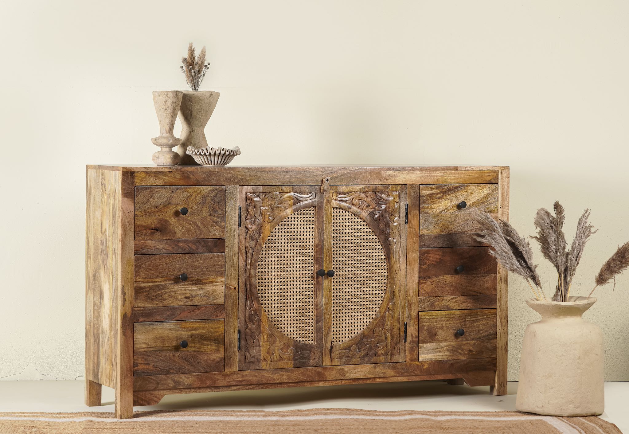 Side angle image of a hand-carved wood furniture sideboard with floral motifs and rattan cabinet doors, solid mango wood rattan furniture, 160 × 40 × 90 cm.