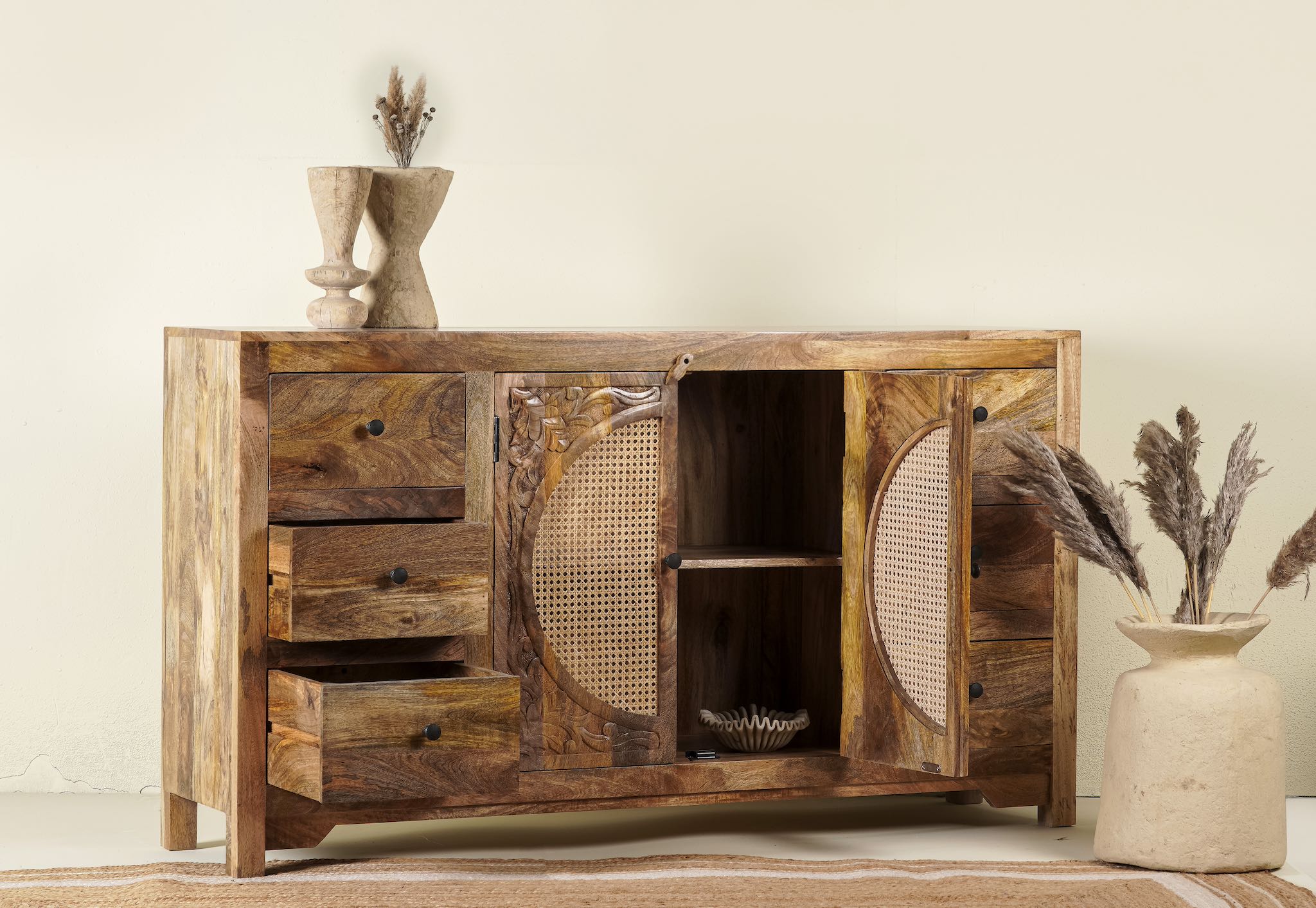 Open door image of a hand-carved wood furniture sideboard with floral motifs and rattan cabinet doors, solid mango wood rattan furniture, 160 × 40 × 90 cm.
