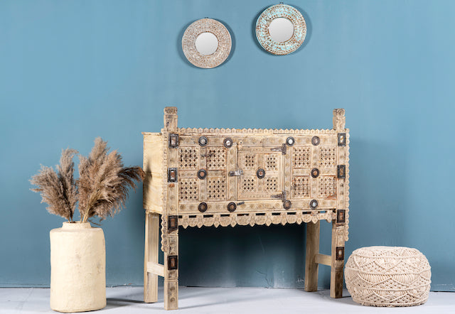 Side angle image of a sandblasted antique Indian teak chest with hand-carved details, original iron fittings, and a naturally aged finish, ideal for bohemian or vintage-inspired interiors.