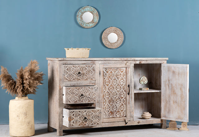 Side angle image with open door of a hand‑carved vintage style mango wood sideboard with distressed floral lattice panels, 150 × 40 × 90 cm.