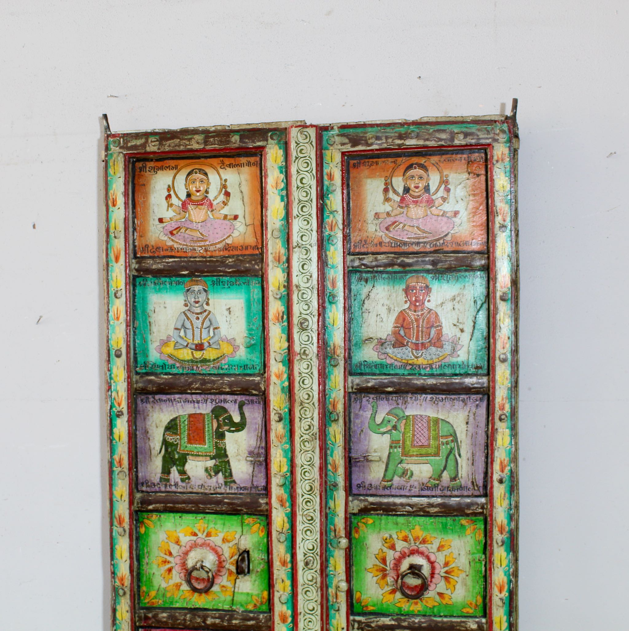 Close up image of an antique Indian teak door panel with hand-painted religious motifs, vintage wall panels and vintage home decor.