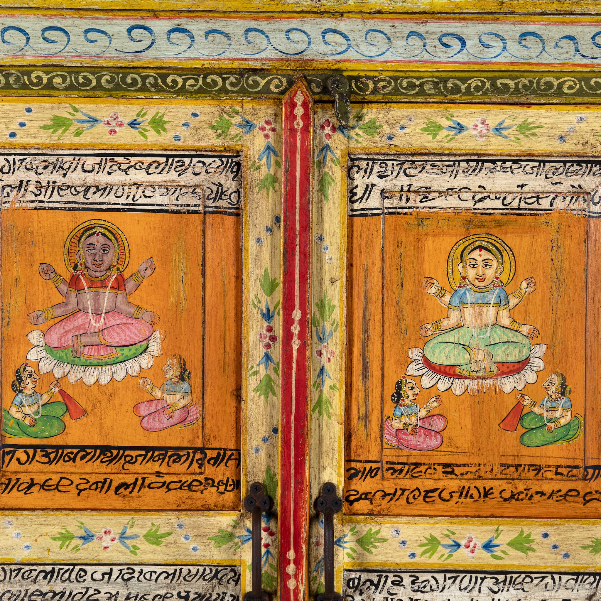 Close up image of a hand-painted reclaimed wood cabinet with Indian gods, floral motifs, and distressed finish; unique furniture for vintage home decor, 90 × 40 × 150 cm.