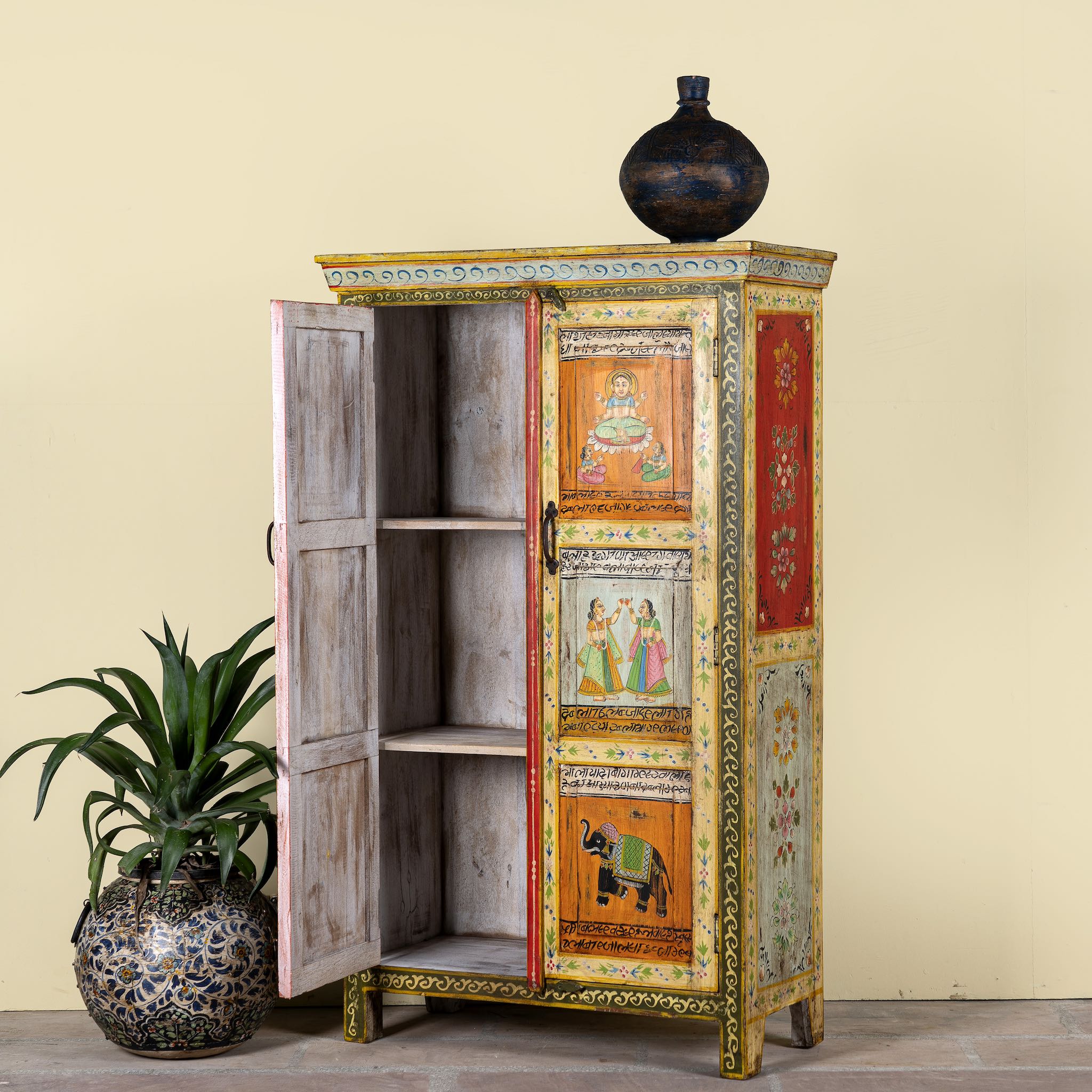 Side angle with open door image of a hand-painted reclaimed wood cabinet with Indian gods, floral motifs, and distressed finish; unique furniture for vintage home decor, 90 × 40 × 150 cm.
