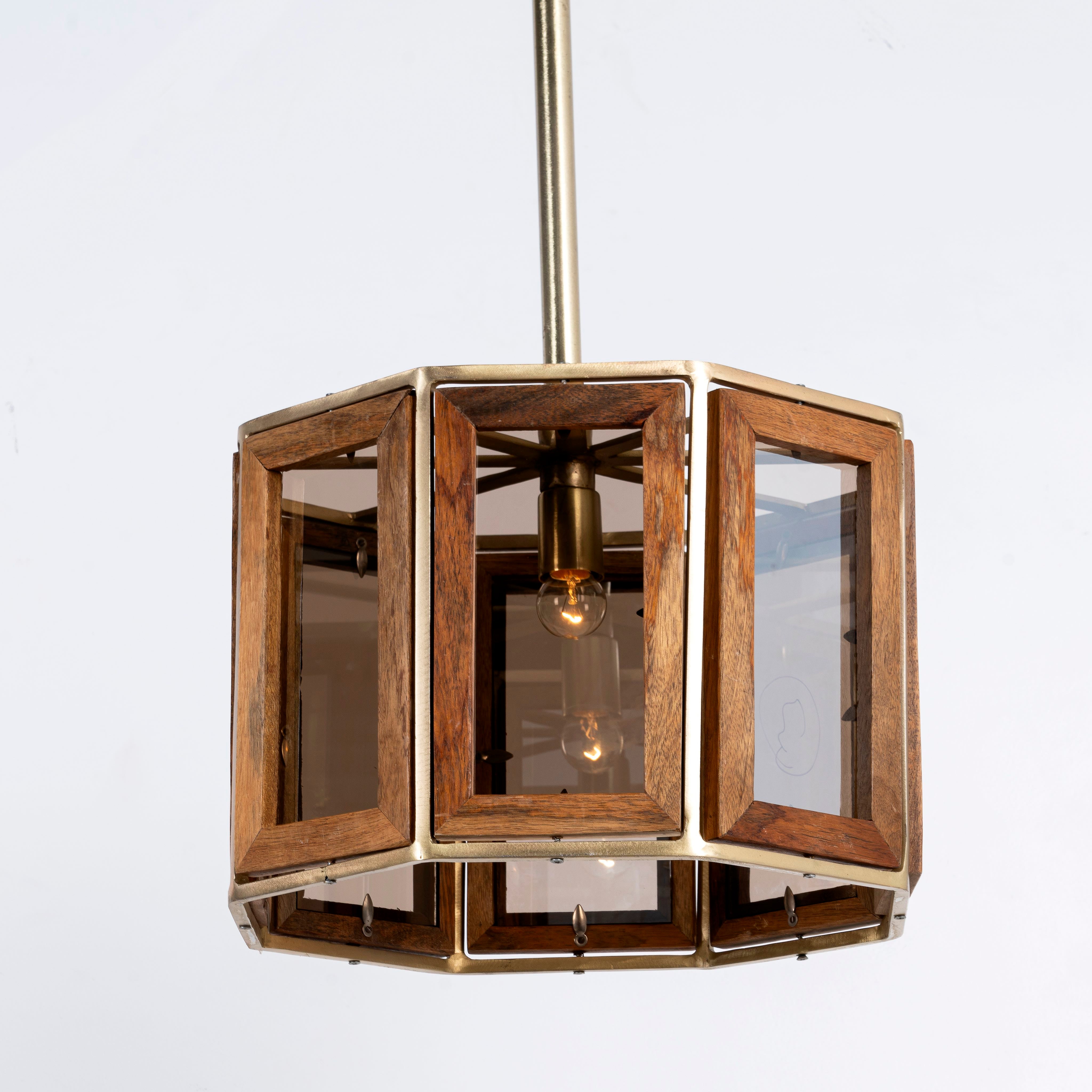 White background image of a octagon-shaped mango wood pendant lamp with antique brass finish – handcrafted wooden lamp ideal for industrial style lighting in compact interiors.