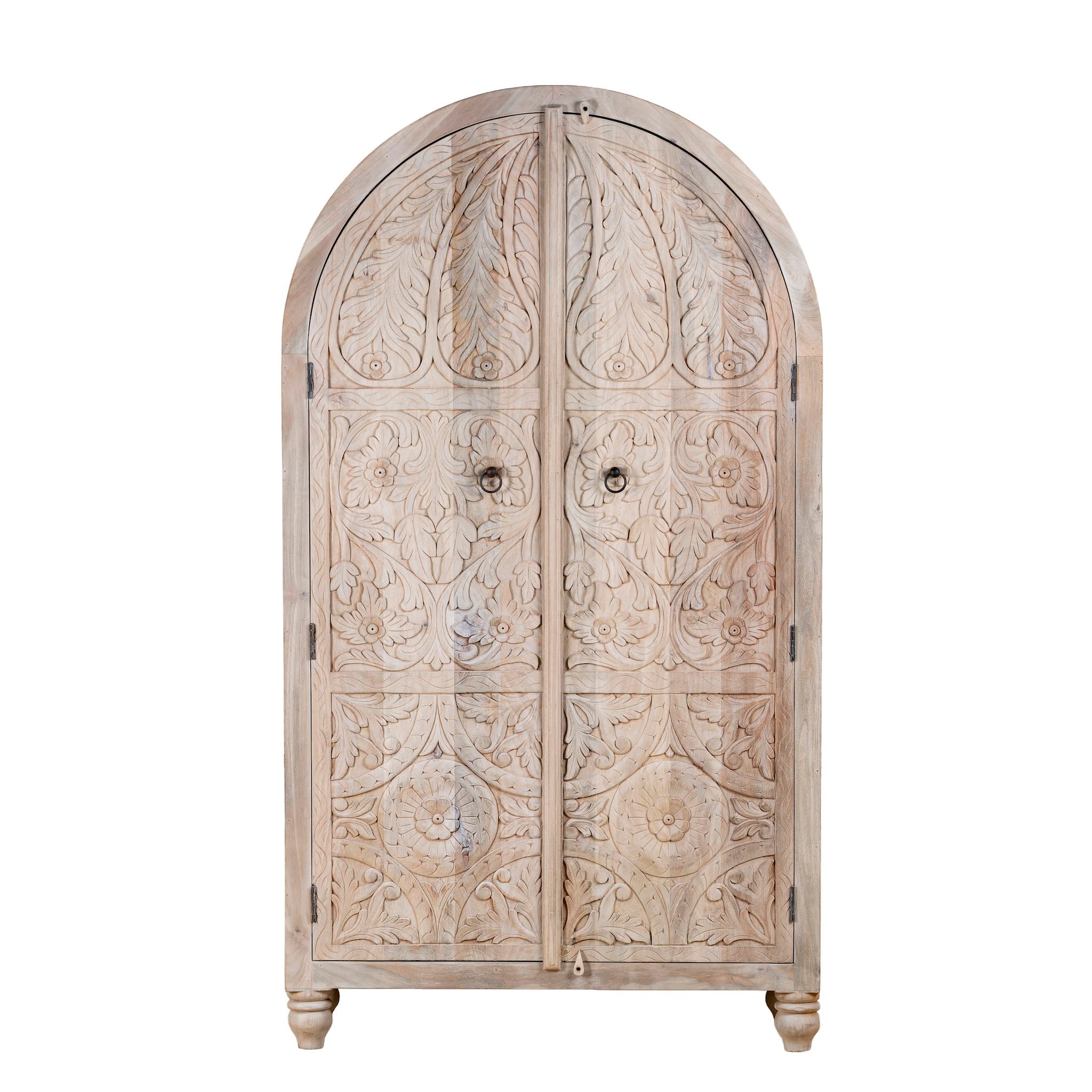 White background image of a handcrafted mango wood wardrobe with arched top and floral carving – Tamia by Om Home & Garden, unique furniture with Ibiza-style charm for living rooms and bedrooms.